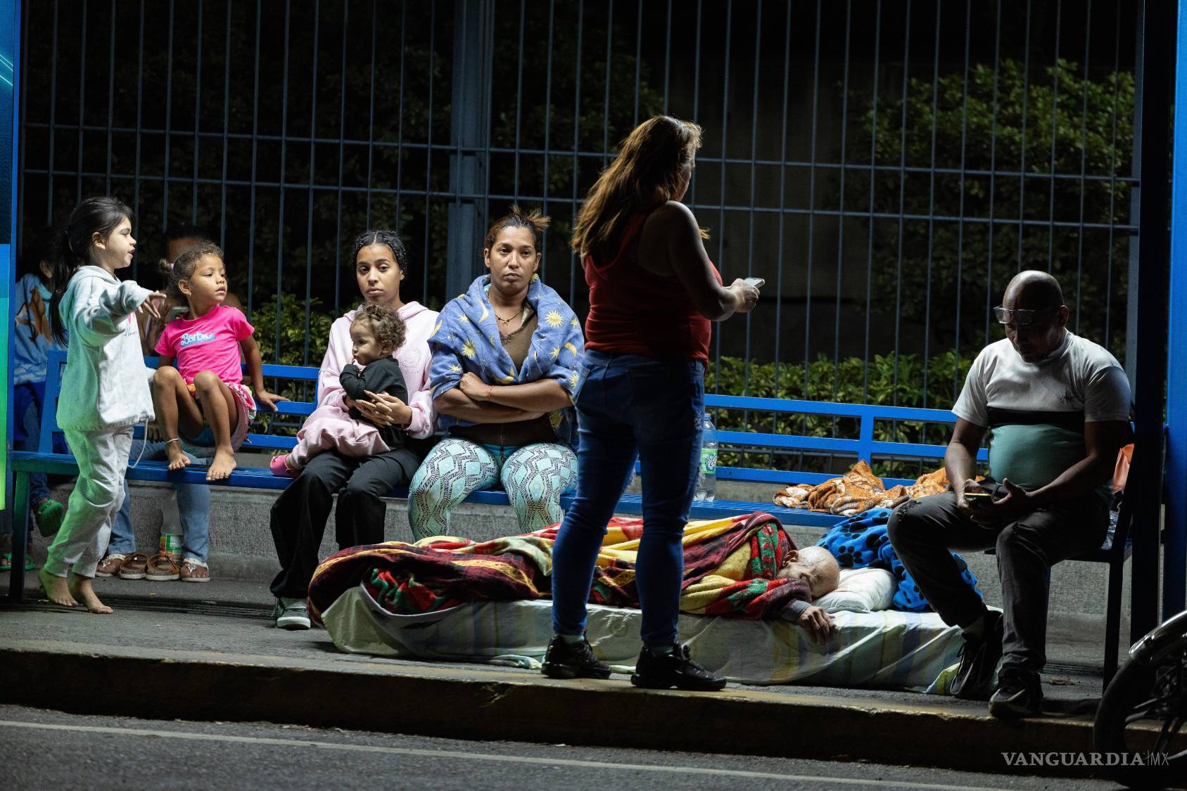 $!Personas esperan en una parada de bus, luego de dos fuertes terremotos que sacudieron el Caribe venezolano, en Caracas (Venezuela). El principal fue un sismo de magnitud 7,5, informó el sistema oficial de alerta de tsunamis de Estados Unidos.