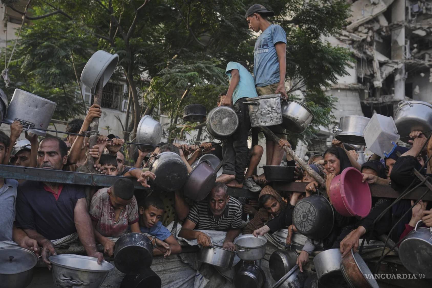 $!Palestinos luchan por recibir alimentos donados en un comedor comunitario en la ciudad de Gaza, al norte de la Franja de Gaza, el 14 de julio de 2025.
