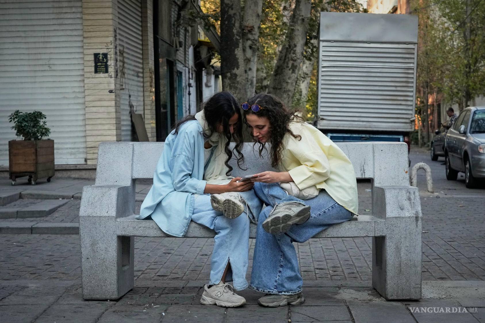 $!Dos mujeres usan un teléfono inteligente en el norte de Teherán, Irán.