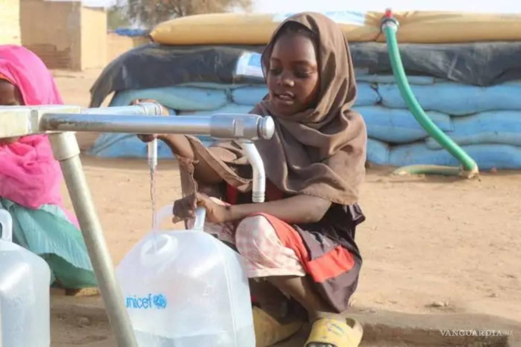 $!Una niña desplazada por el conflicto en El Fasher recoge agua de un punto de abastecimiento instalado por UNICEF en un campamento en Tawila, Darfur del Norte.
