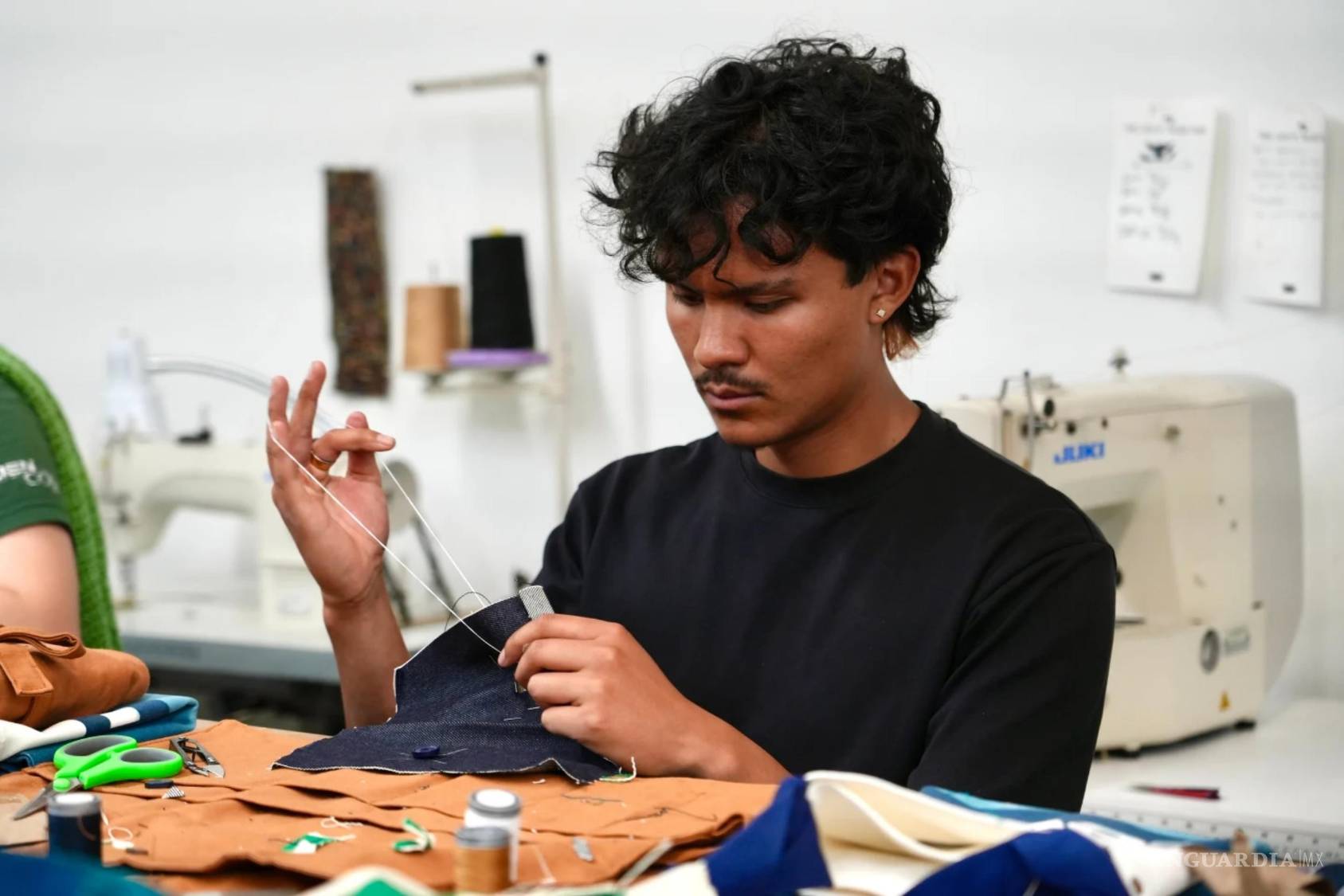 $!esse Sanchez practica la costura durante un taller de reparación de ropa en una tienda Levi’s del centro de San Francisco, el miércoles 22 de julio de 2026.