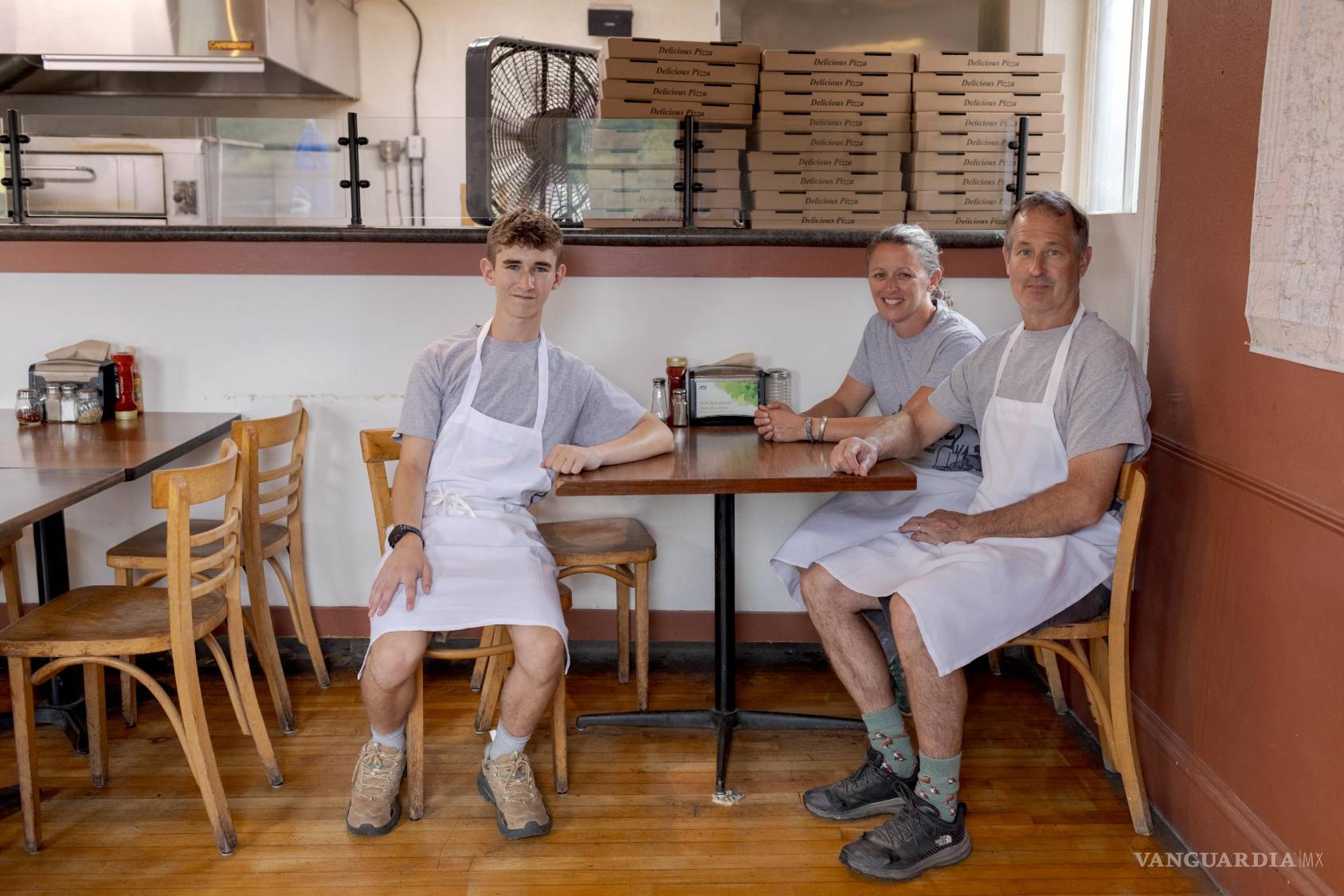 $!De izquierda a derecha, Dean Roy, de 15 años, con sus padres Chessie y James Roy en la pizzería de su familia en Stowe, Vermont, el 11 de agosto de 2026.