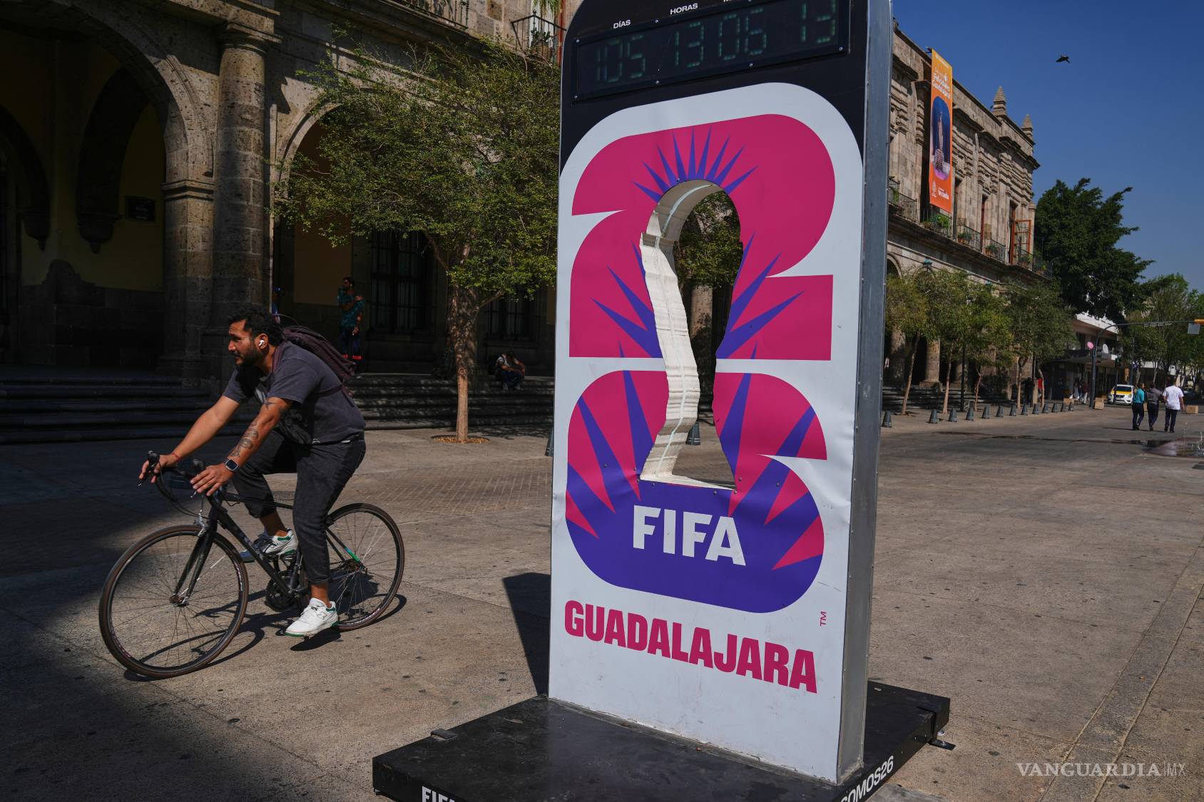 $!Un ciclista pasa junto a un promocional de la Copa Mundial 2026 en Guadalajara, Jalisco (México).