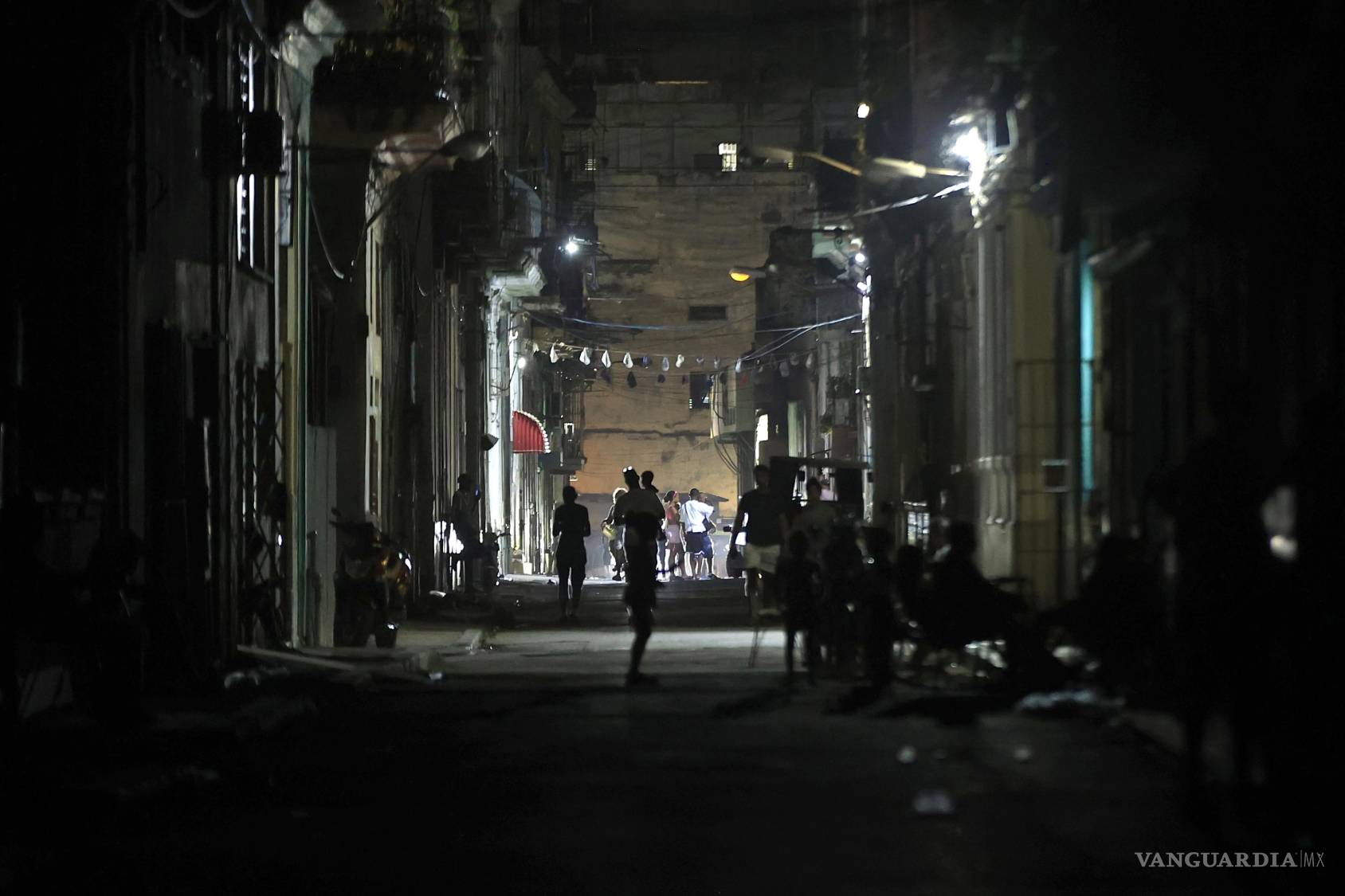 $!Personas caminan durante un apagón por una calle en La Habana. El Sistema Electroenergético Nacional se recupera paulatinamente de la desconexión total.