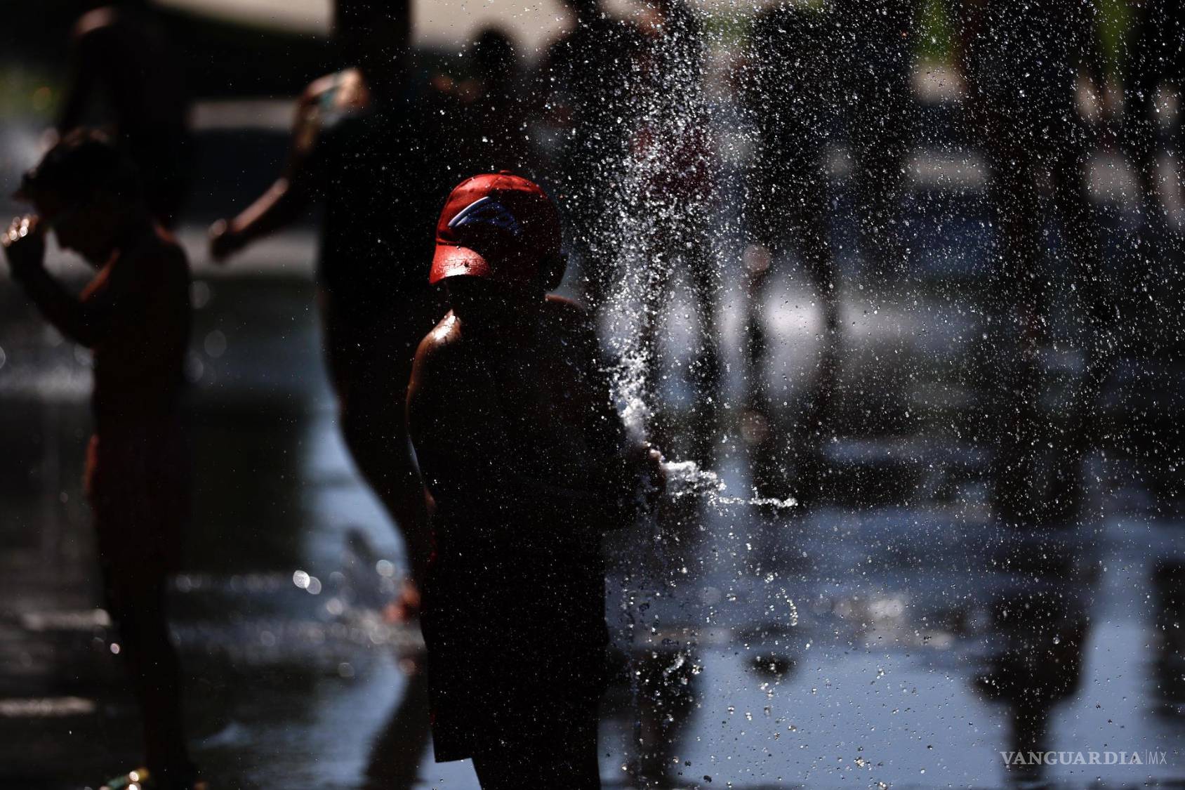 $!Un niño se refresca en unos de los chorros de agua de Madrid durante la ola de calor.