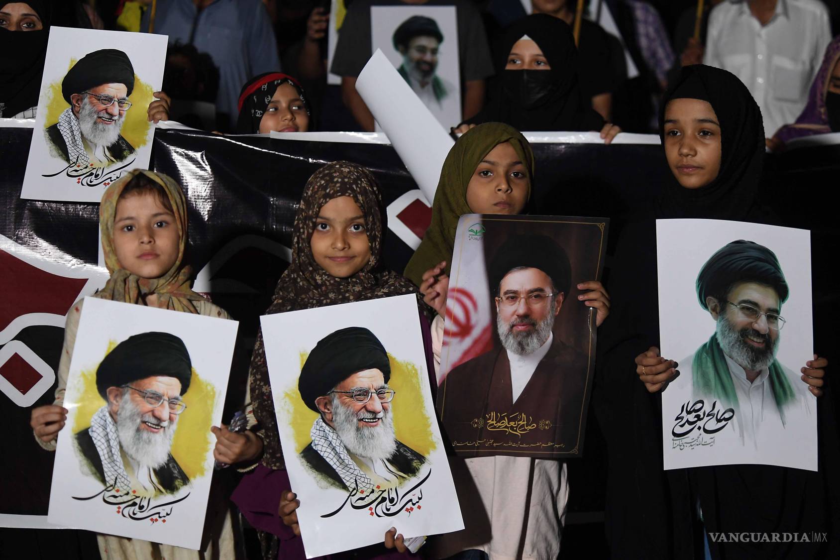 $!Musulmanes chiítas paquistaníes con retratos del líder supremo iraní, el ayatolá Mojtaba Khamenei, y del difunto líder supremo iraní, el ayatolá Ali Khamenei.