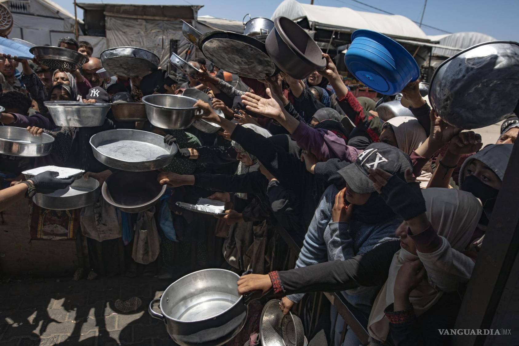 $!Palestinos desplazados se reúnen para recibir comidas calientes de un comedor social en Khan Yunis, al sur de la Franja de Gaza.