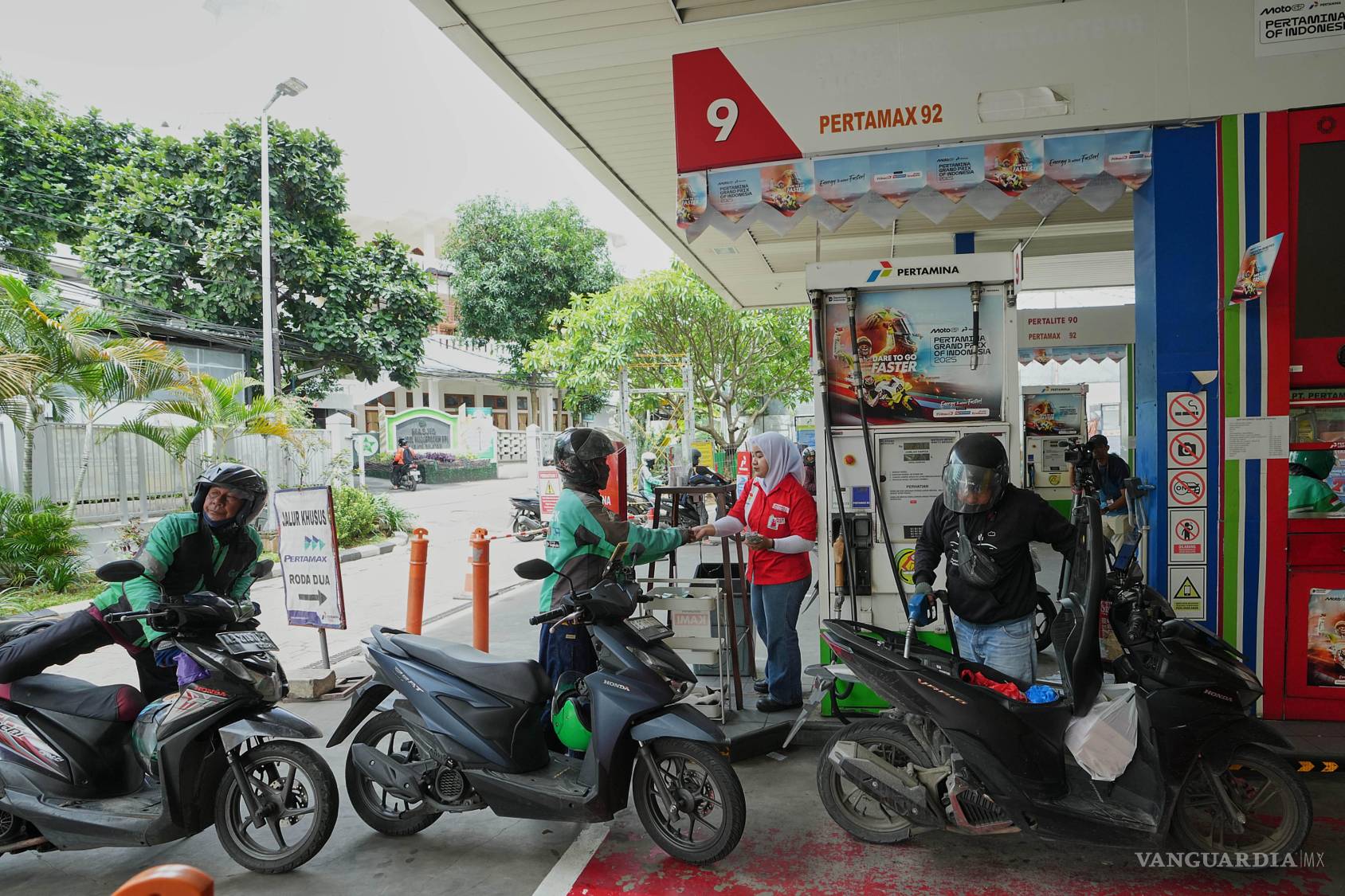 $!La gente hace fila para cargar combustible en sus motocicletas en una gasolinera de Yakarta, Indonesia.