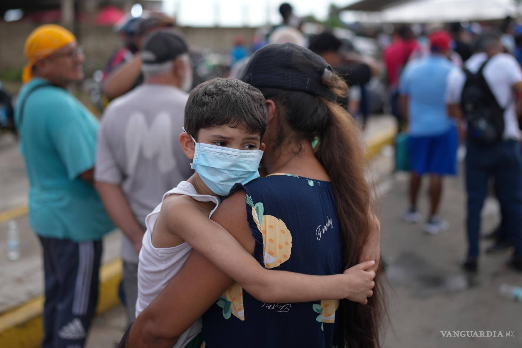 $!Mujer sostiene a su hijo, mientras espera en la fila para recibir ayuda humanitaria del gobierno, días después del terremoto que azotó La Guaira, Venezuela.