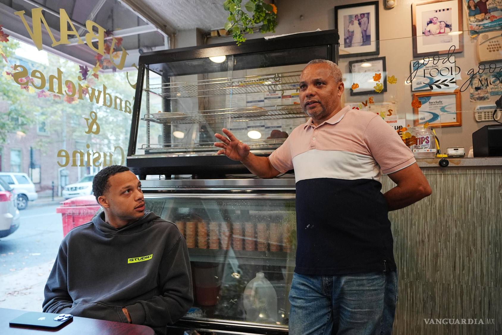 $!Alberto Pena, quien administra el restaurante Las Palmas, que sirve comida dominicana, habla mientras su hijo Miguel observa, en Allentown, Pensilvania