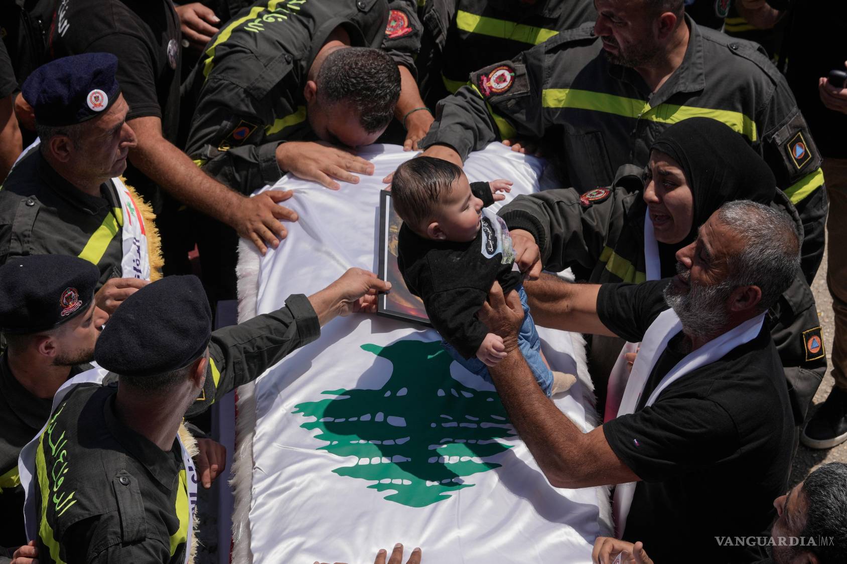 $!Un hombre, a la derecha, coloca al hijo de cinco meses de Hussein Ali Satti, miembro de la Defensa Civil libanesa quien murió en un ataque israelí.