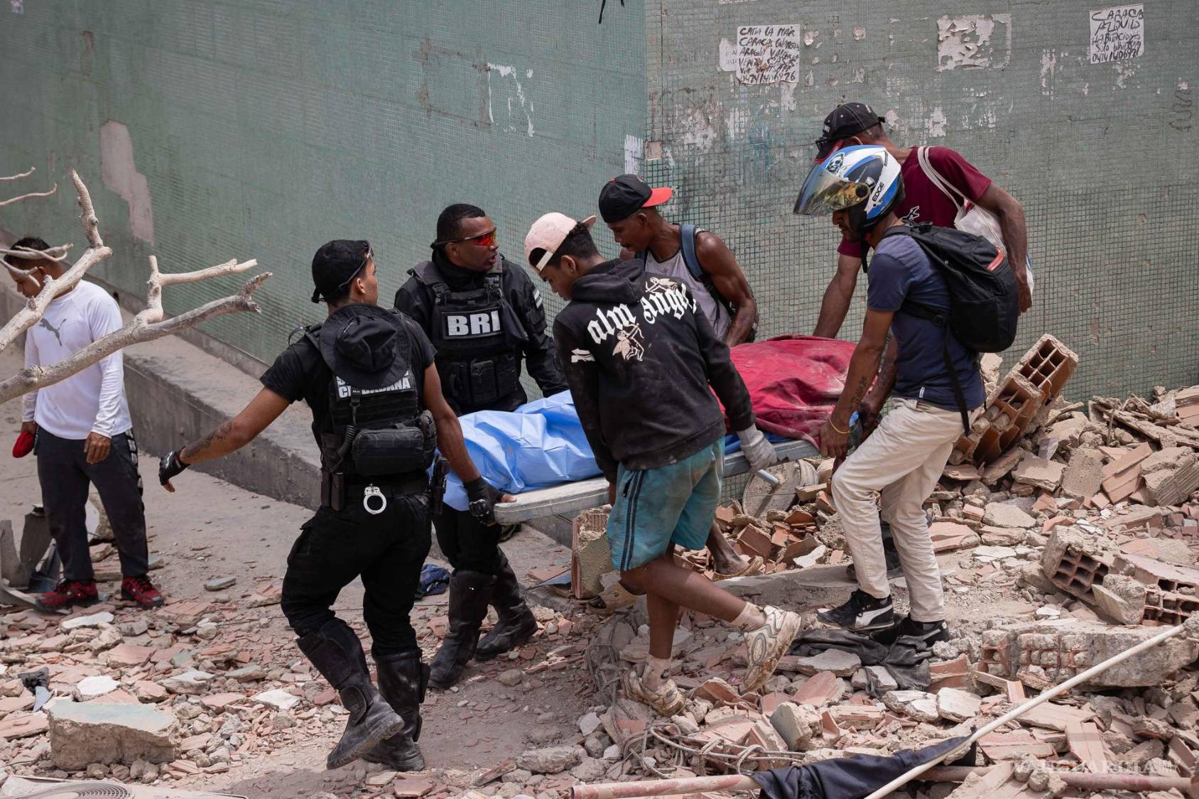 $!Voluntarios rescatan una víctima mortal este jueves, entre los escombros de edificios afectados por los terremotos en La Guaira, Venezuela.