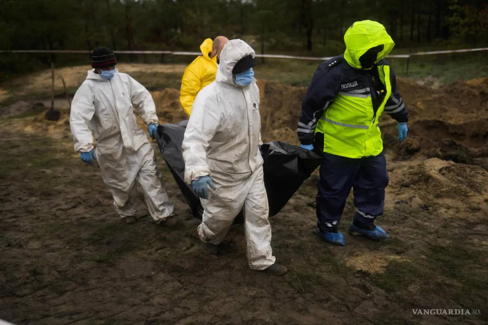 $!Un equipo forense transporta un cuerpo mientras trabajan en la exhumación de una fosa común en Limán, Ucrania, el martes 11 de octubre de 2022.