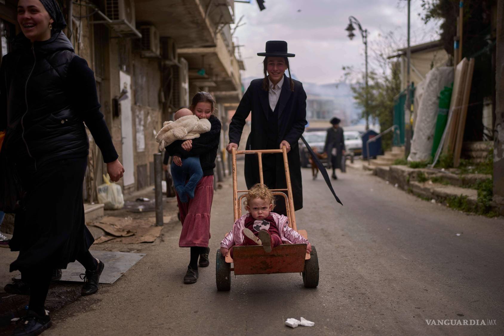 $!Un niño es transportado en una carretilla en el barrio ortodoxo de Mea Shearim en Jerusalén durante los preparativos finales para la festividad de la Pascua.