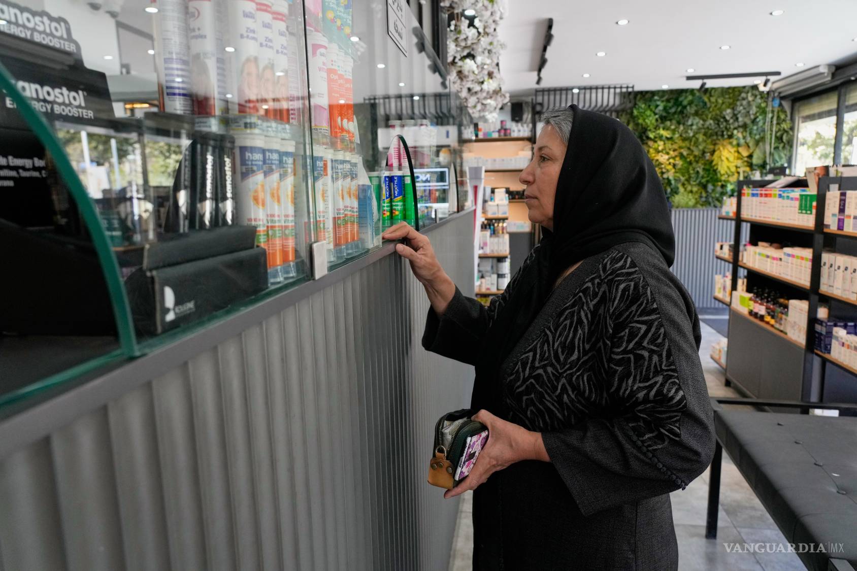 $!Una mujer recibe su medicamento en una farmacia de Teherán, Irán, el viernes 21 de agosto de 2026.