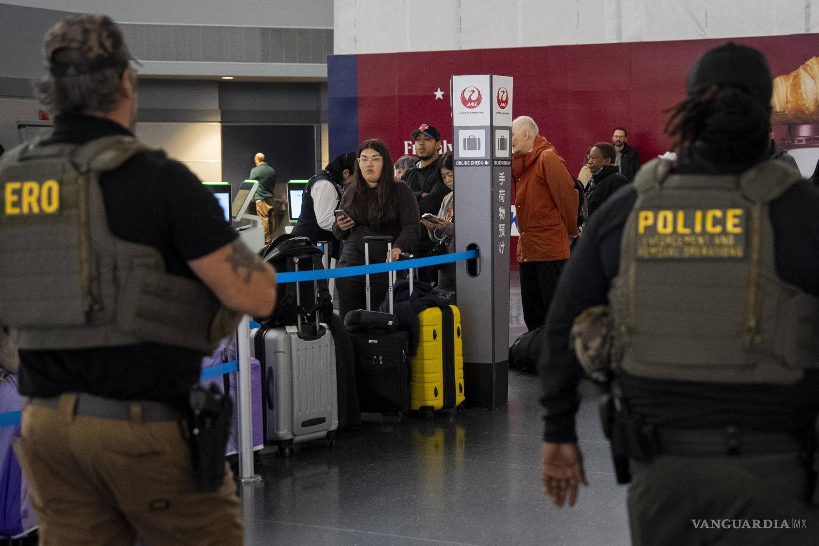 $!Los pasajeros observan cómo agentes federales de inmigración patrullan el Aeropuerto Internacional John F. Kennedy de Nueva York, el lunes 23 de marzo de 2026.