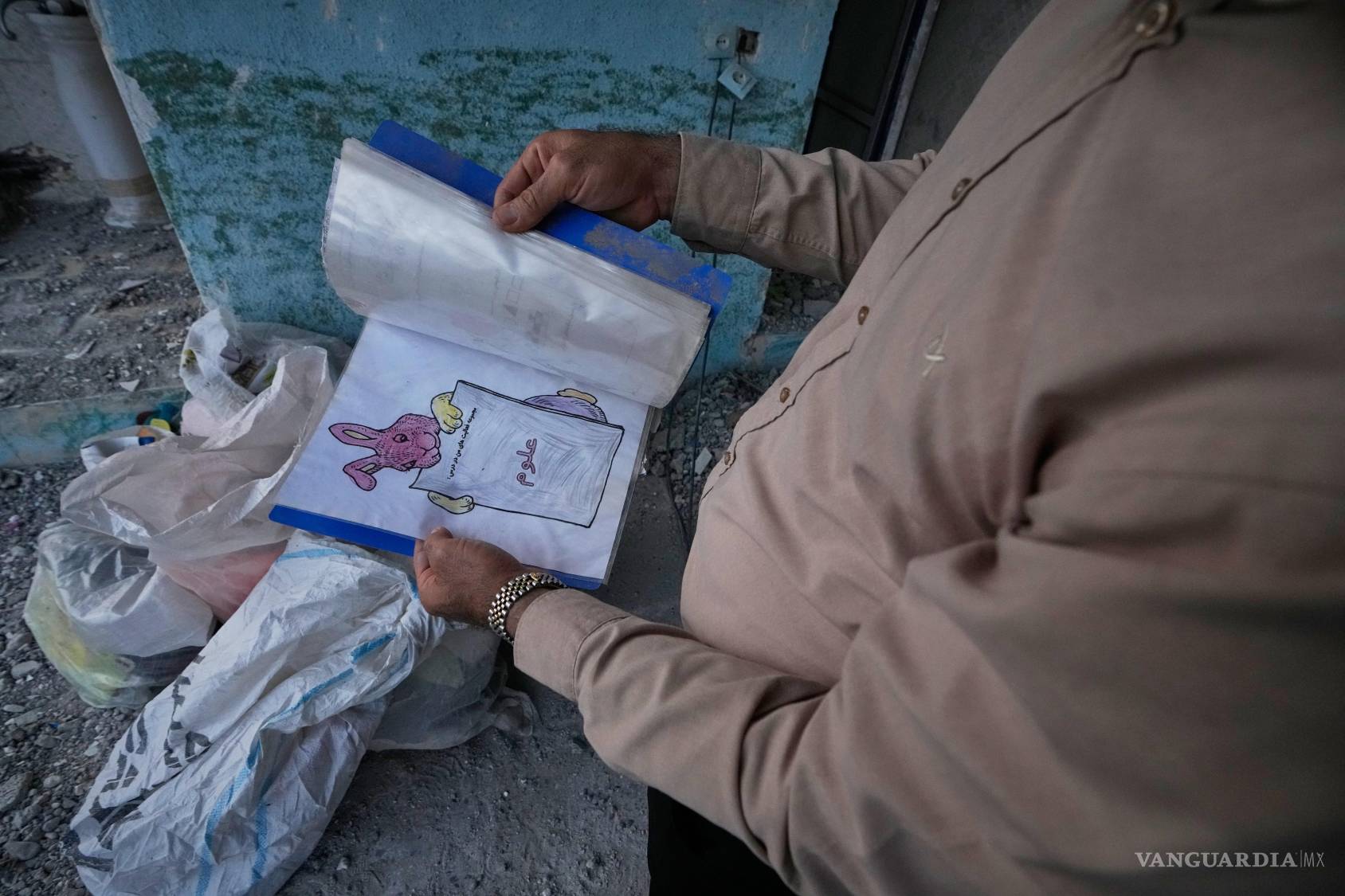 $!Un voluntario sostiene el cuaderno de un niño recuperado de la escuela Shajareh Tayyebeh —atacada el 28 de febrero por un ataque aéreo estadounidense— en Minab, en el sur de Irán, el lunes 7 de septiembre de 2026.