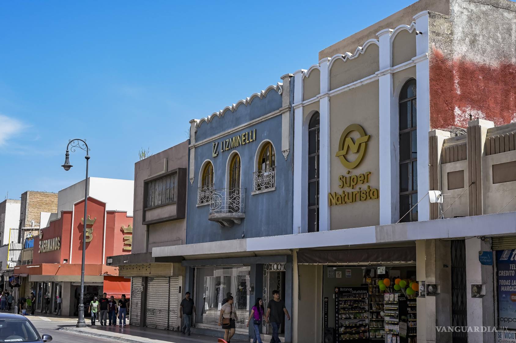 $!Las zapaterías ocupan la planta baja de la calle Victoria, mientras balcones, ventanas y segundos pisos quedan subordinados a los anuncios comerciales. Sobre los escaparates todavía permanece una ciudad suspendida. Algunos, en tono de broma, han dicho que el destino de la ciudad es convertirse en una zapatería gigante haciendo que la capital pierda toda identidad.