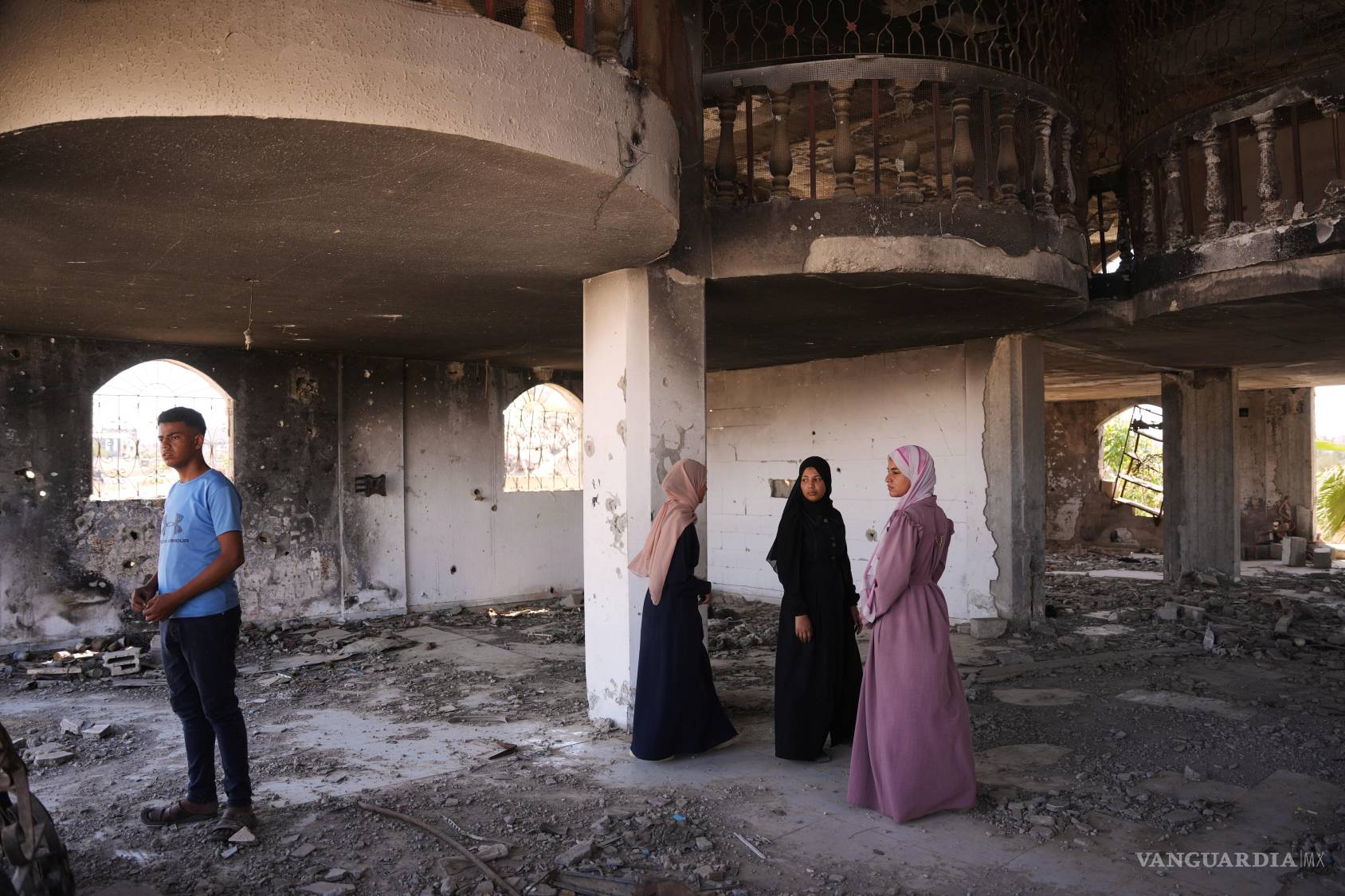 $!Fady al-Gharam (izquierda) y sus hermanas inspeccionan la casa de su familia, dañada durante la guerra entre Israel y Hamás, en Nuseirat, en el centro de la Franja de Gaza, el 4 de junio de 2026, mientras están en proceso de obtener pasaportes israelíes.