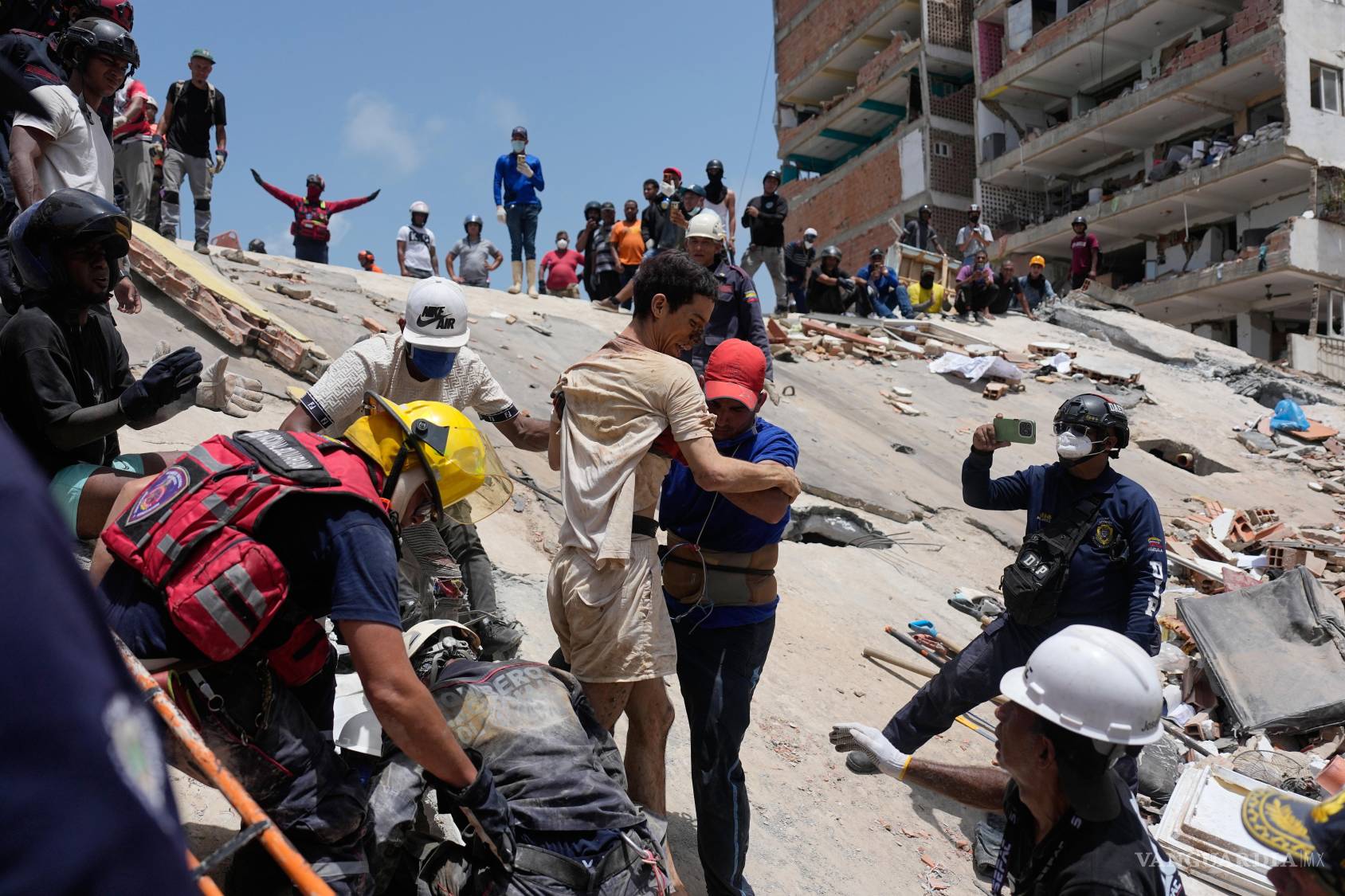 $!Los rescatistas ayudan a Daniel Cordero tras sacarlo de entre los escombros dos días después del terremoto que azotó Catia la Mar, Venezuela.
