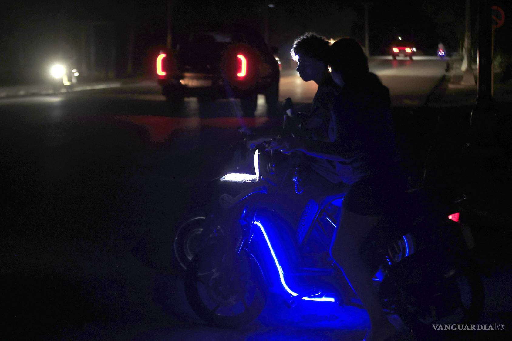 $!Personas en motos eléctricas esperan durante un apagón que ocurrió este lunes en La Habana (Cuba).