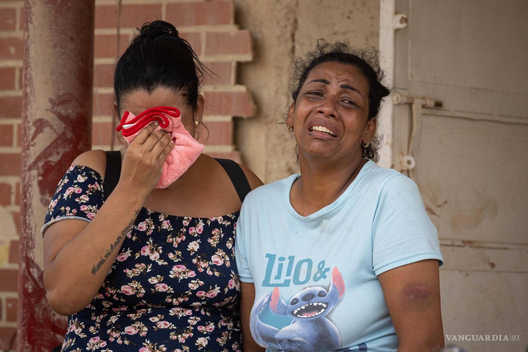 $!Personas lloran al observar escombros de edificios derrumbados por terremotos este jueves, en La Guaira ,Venezuela.