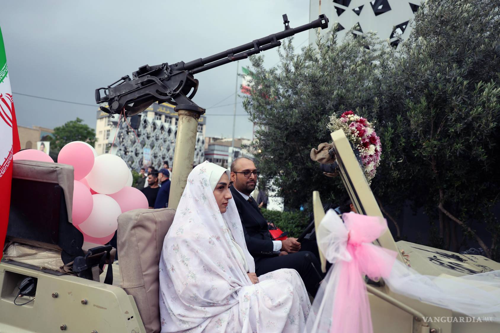 $!Una pareja iraní llega en un vehículo militar a una ceremonia nupcial colectiva organizada en el marco de la campaña “Jan-Fada” (Sacrificio de la Vida) en Teherán.