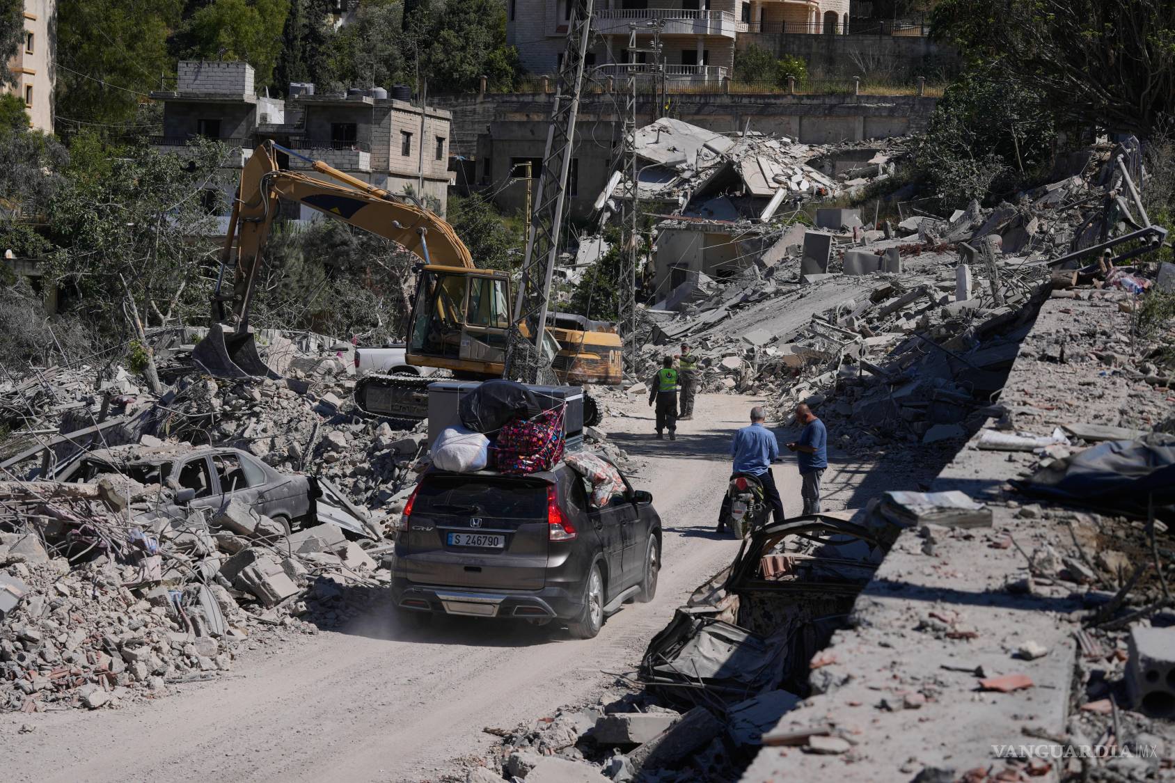 $!Habitantes que regresan a su aldea circulan por una calle dañada por anteriores ataques aéreos israelíes en la aldea sureña de Kherbet Selem, Líbano.