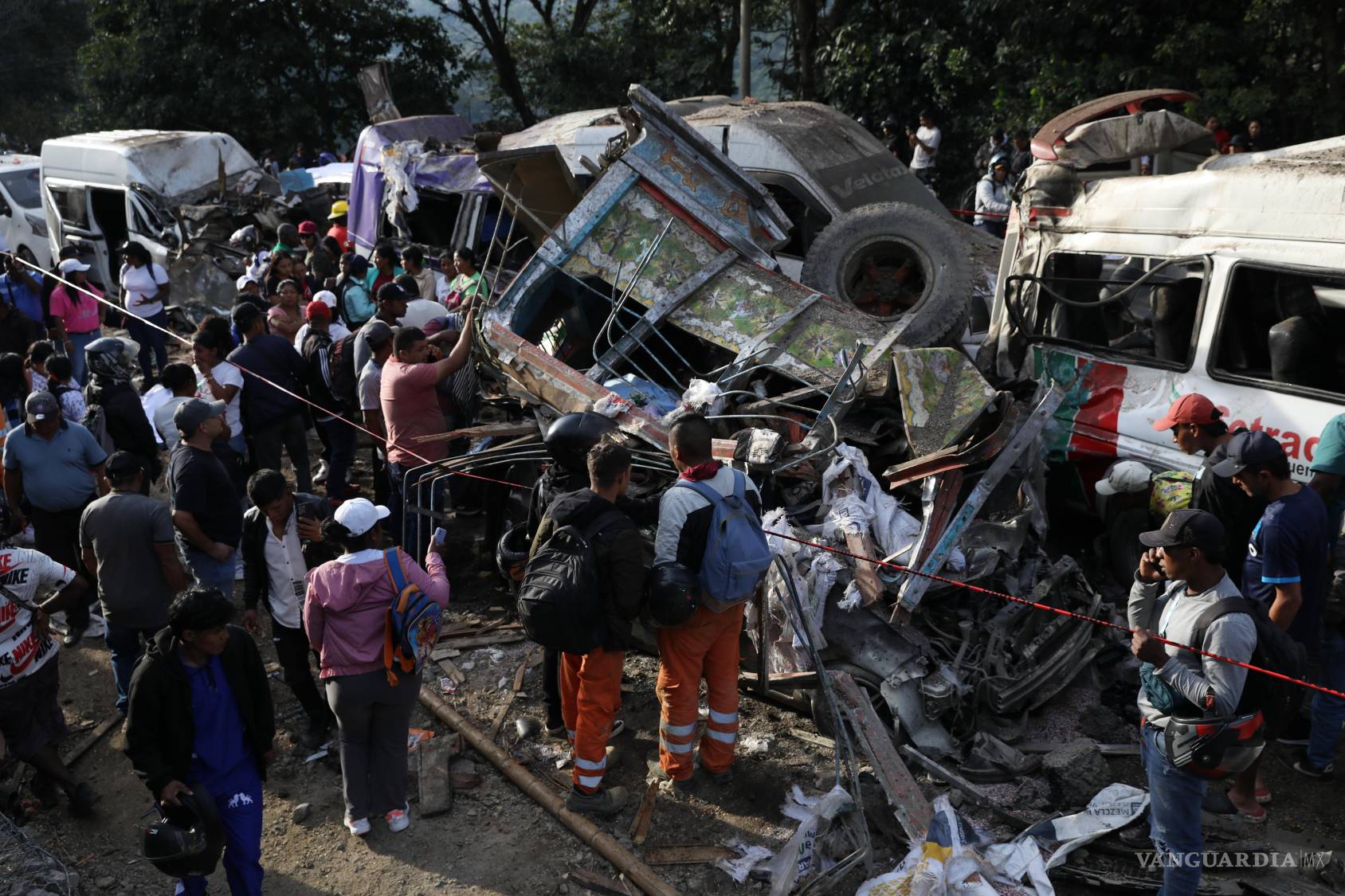 $!Gente reunida en torno a vehículos dañados en un ataque en la autopista Panamericana en Cajibio, Colombia que mató al menos a una docena de personas.