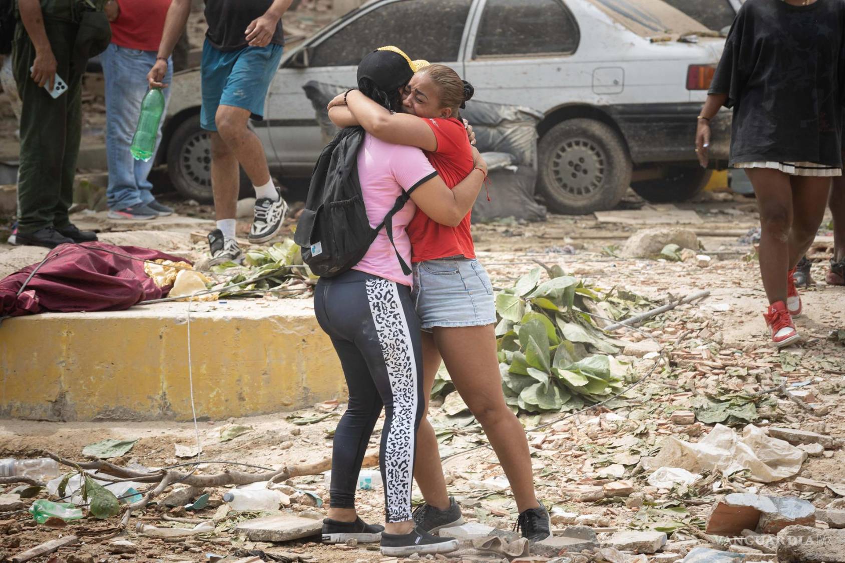 $!Personas lloran frente a escombros de edificios afectados por terremotos este jueves, en La Guaira, Venezuela.