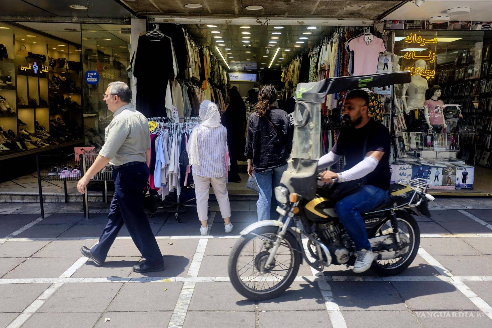 $!Varias personas hacen compras en tiendas cerca de la plaza Valiasr, en el centro de Teherán.