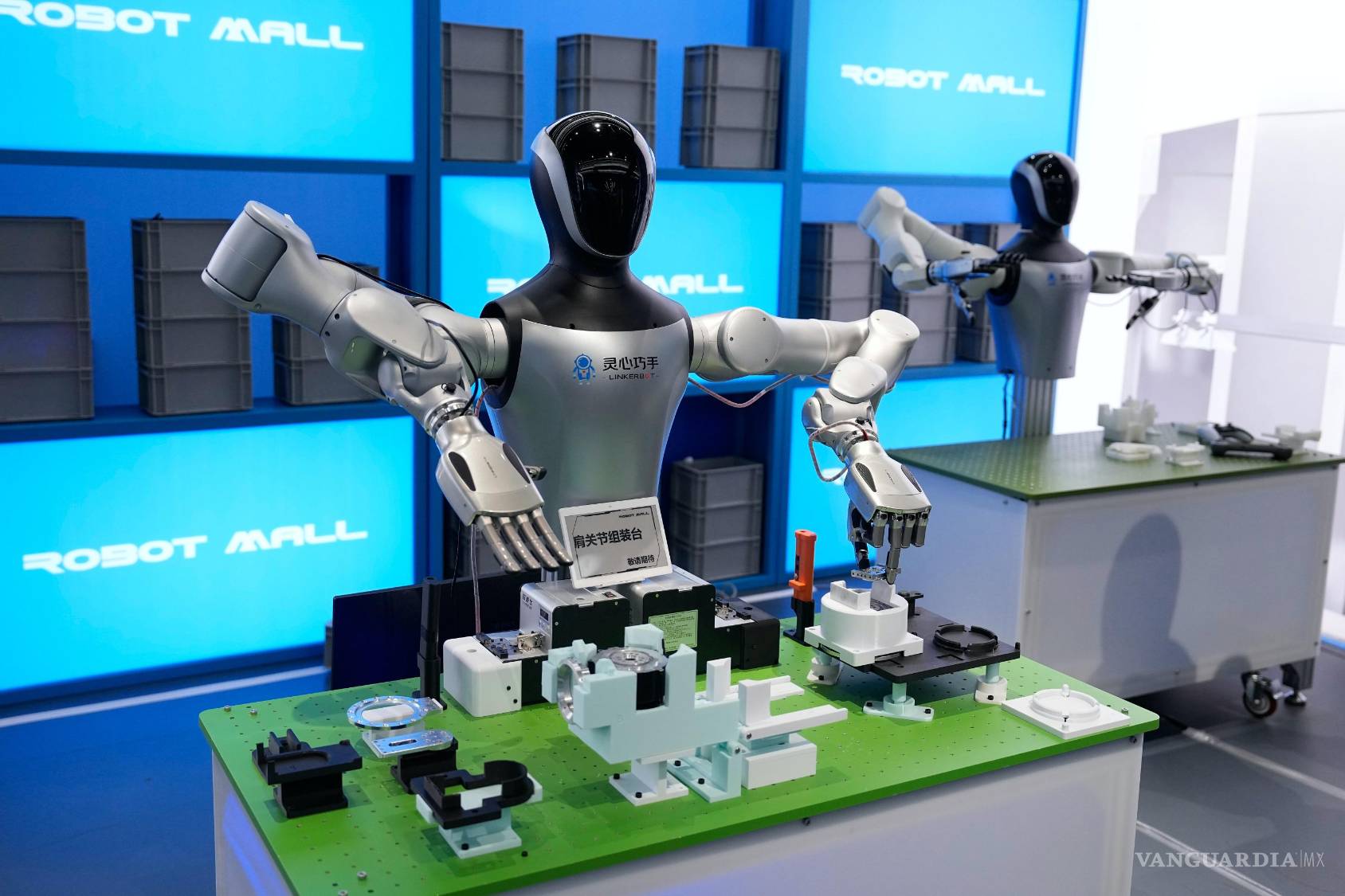 $!Robots ensamblan piezas de maquinaria en el Centro de Innovación de Robótica Humanoide de Pekín durante una visita de prensa en la Ciudad Electrónica.