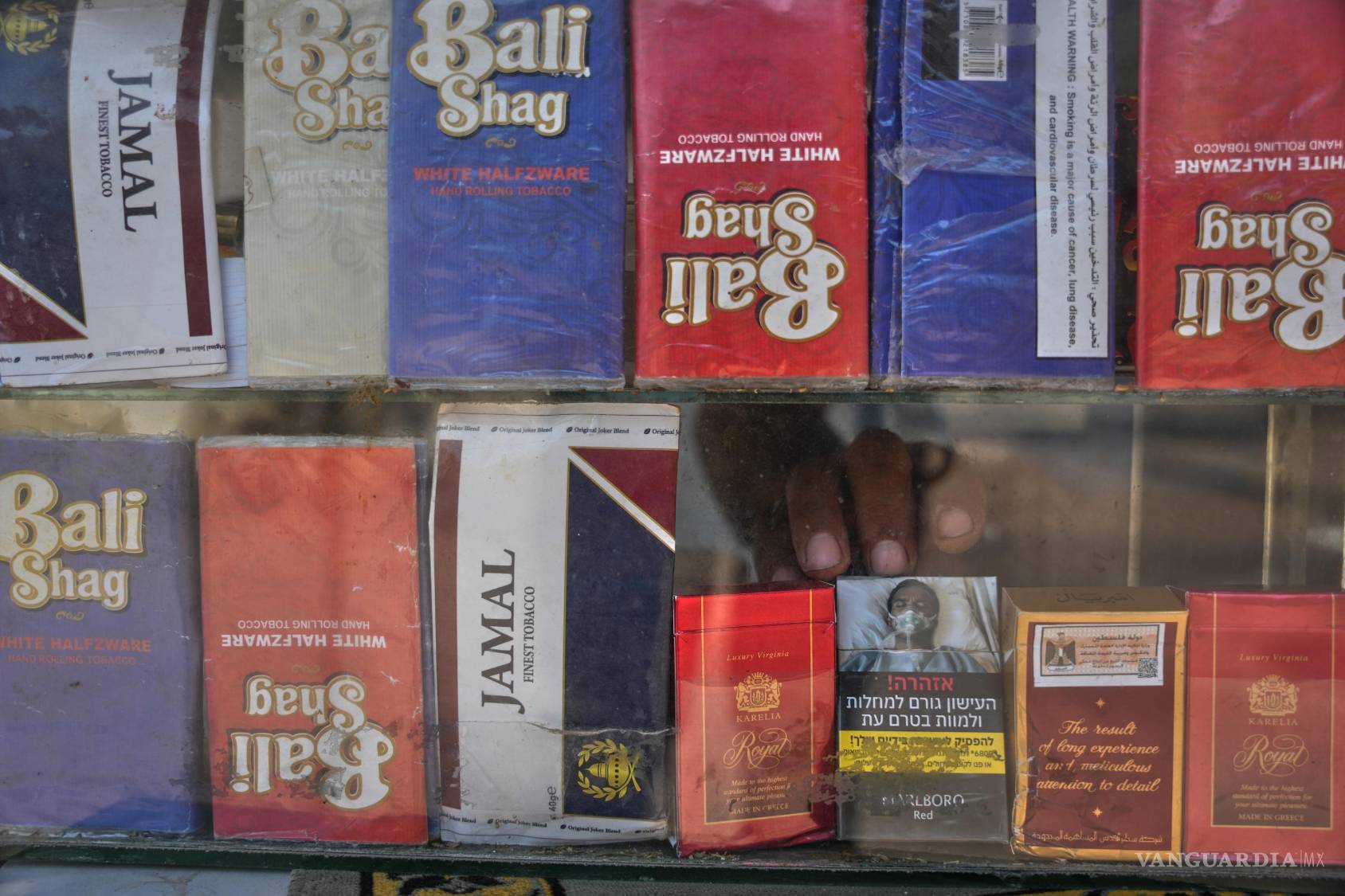 $!Un vendedor toma un paquete de cigarrillos en su quiosco en Deir al-Balah, en el centro de la Franja de Gaza, el 14 de agosto de 2026.