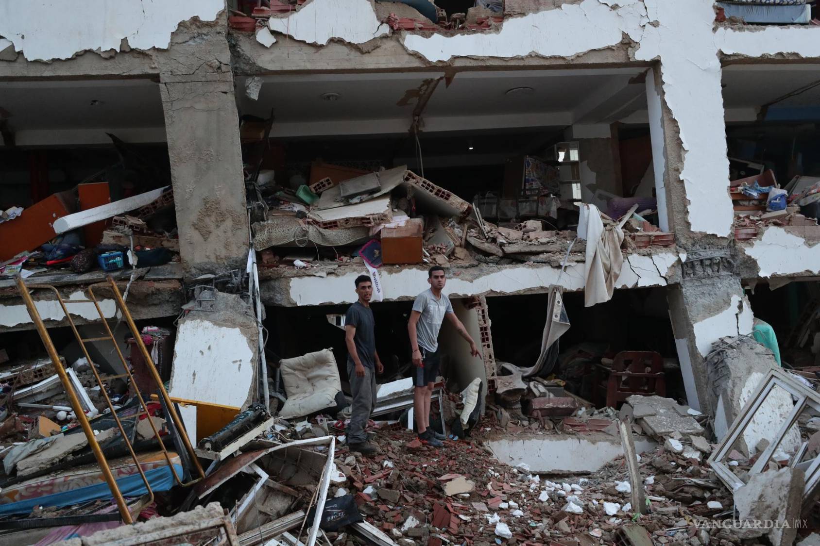 $!Residentes entre los escombros de uno de los bloques de viviendas dañados por los terremotos, en la localidad de Catia La Mar, en el estado costero de La Guaira.