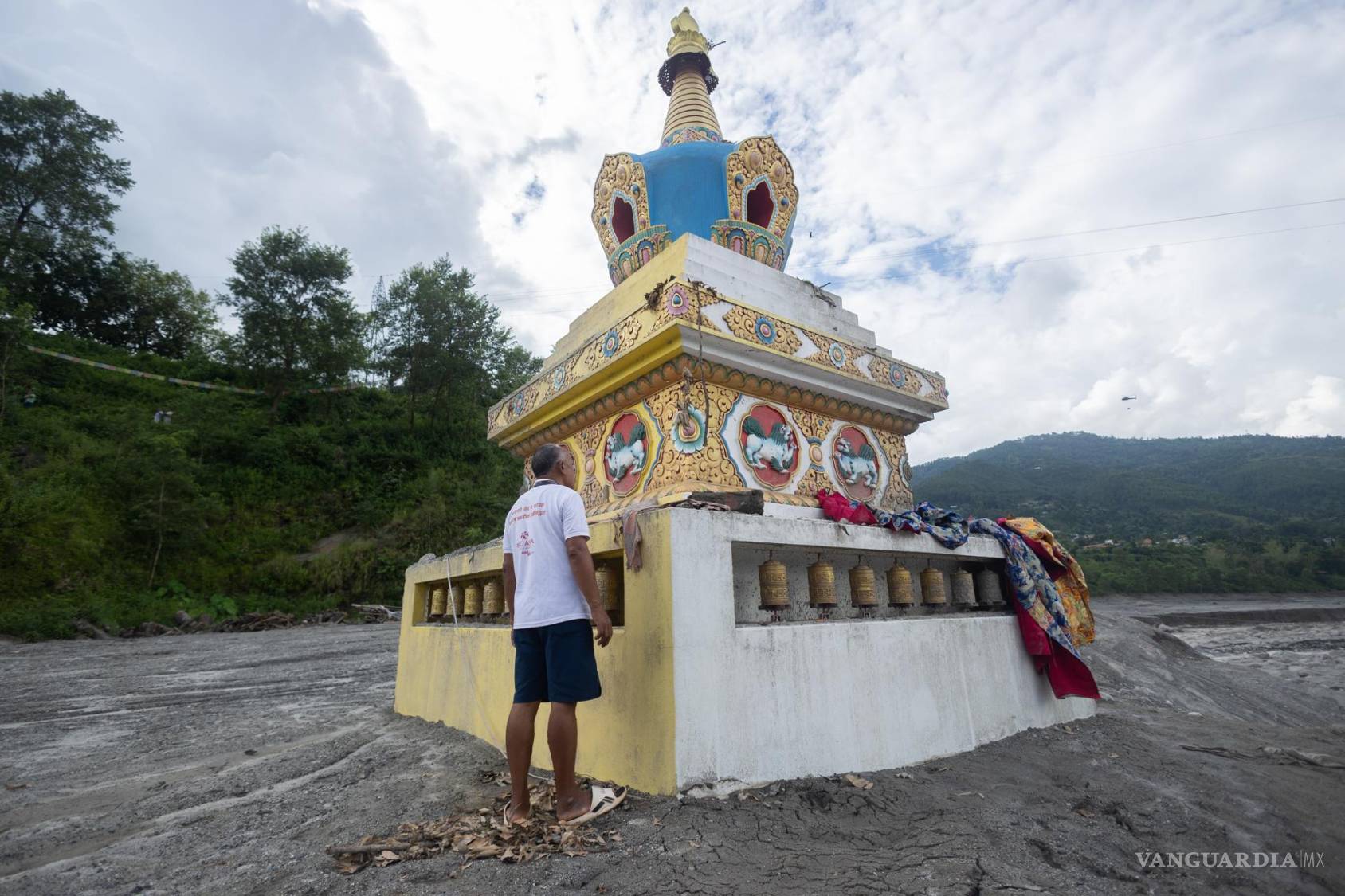 $!Un hombre limpia el monumento a Buda Gautama, afectado por una inundación de origen glaciar que causó cientos de muertes, cerca de la frontera entre Nepal y China, en Trishuli Bazar, Nuwakot, Nepal.
