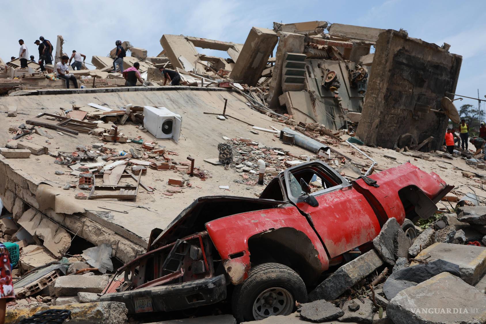 $!Un vehículo quedó aplastado contra un edificio que se derrumbó tras los terremotos que azotaron La Guaira, Venezuela, el jueves 25 de junio de 2026.