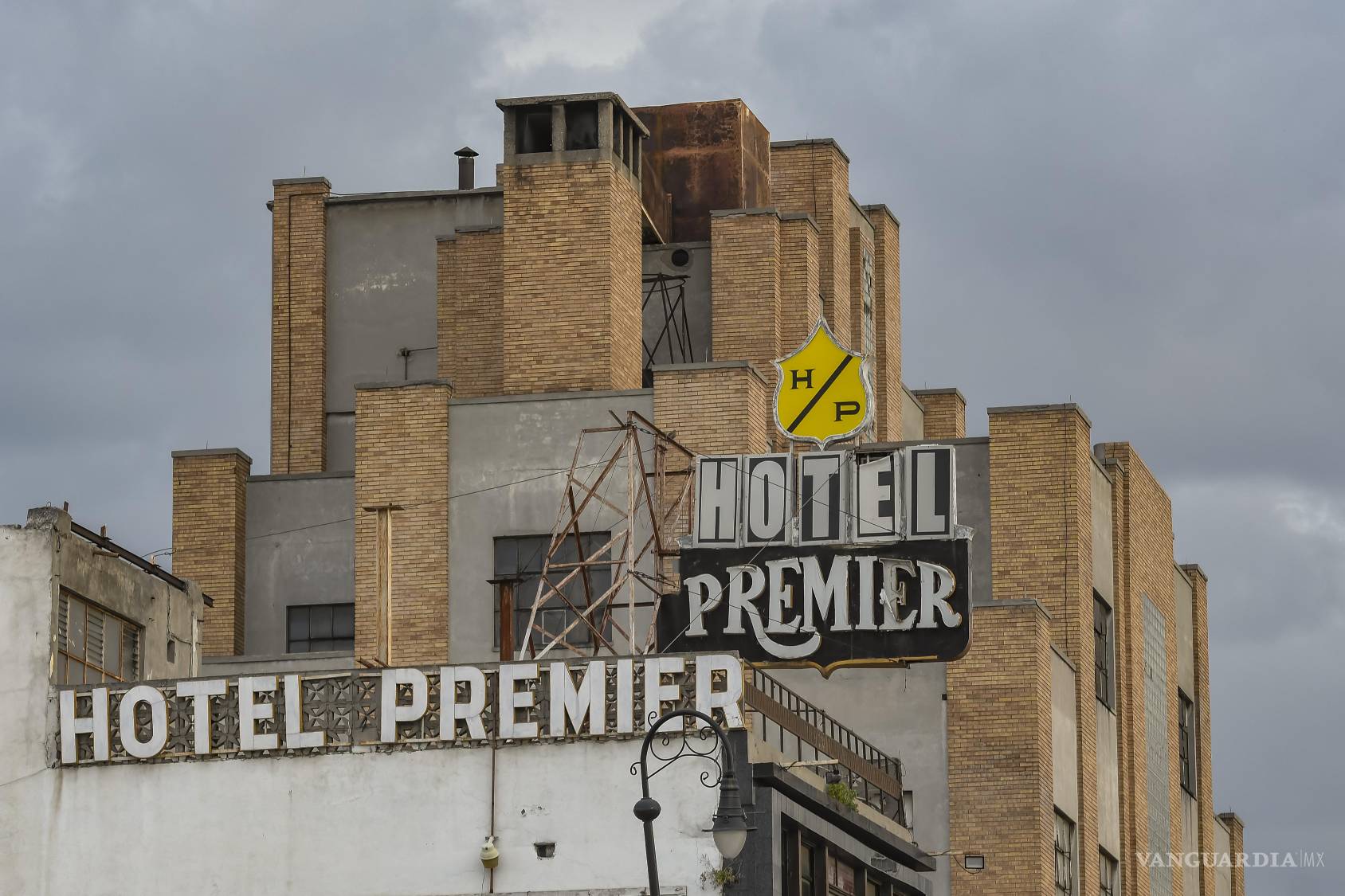 $!El Hotel Premier conserva una de las siluetas verticales del Centro; detrás, las instalaciones del café forman otra capa de una ciudad construida mediante usos, añadidos y transformaciones. Para observarla completa hay que mirar más allá de los anuncios. Por las mañanas, la humerada coneta con un Saltillo atávico.