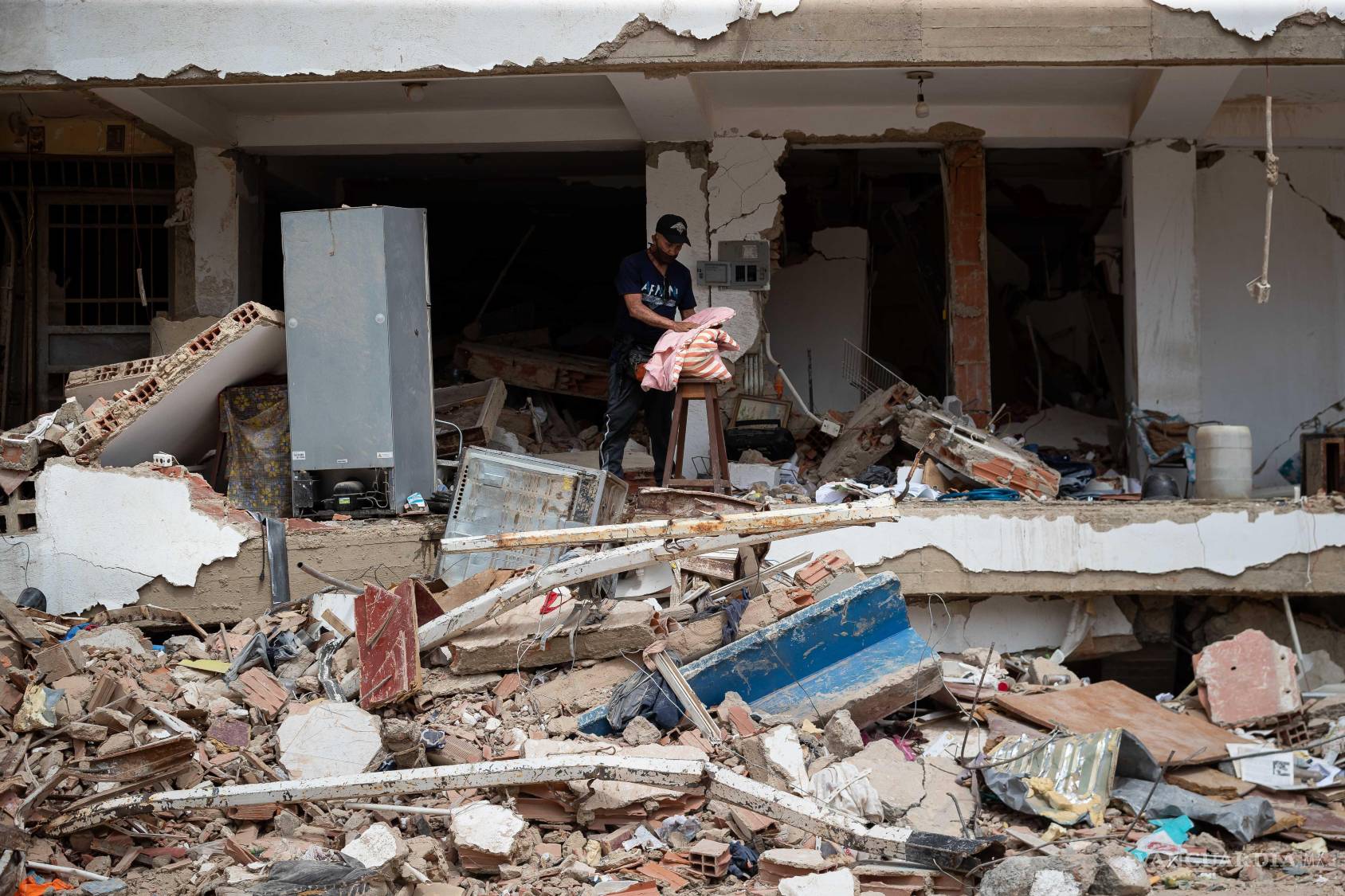$!Una persona buscando pertenencias en medio de los escombros de un edificio, en La Guaira (Venezuela).
