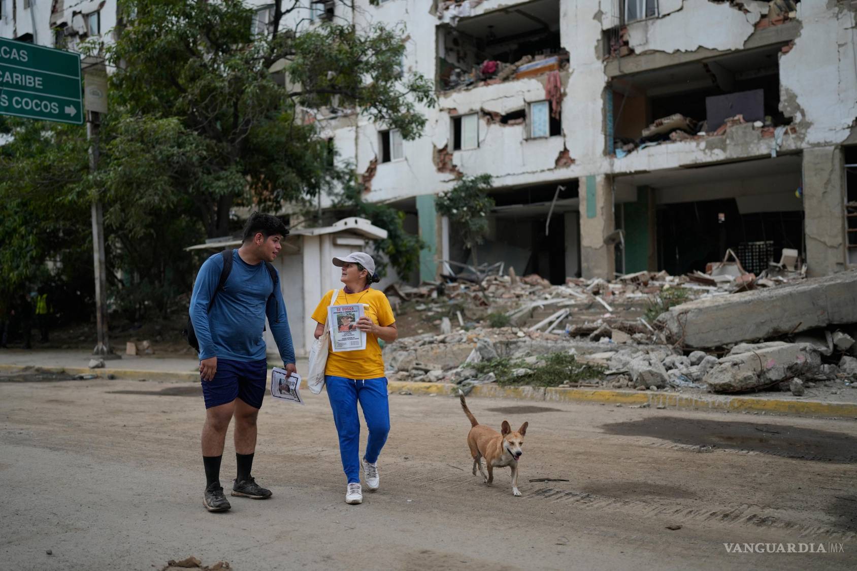 $!Pedro Gómez (i) camina junto a una amiga, preguntando a la gente si ha visto a su primo, Andrés Molina, quien se encuentra desaparecido desde los terremotos.