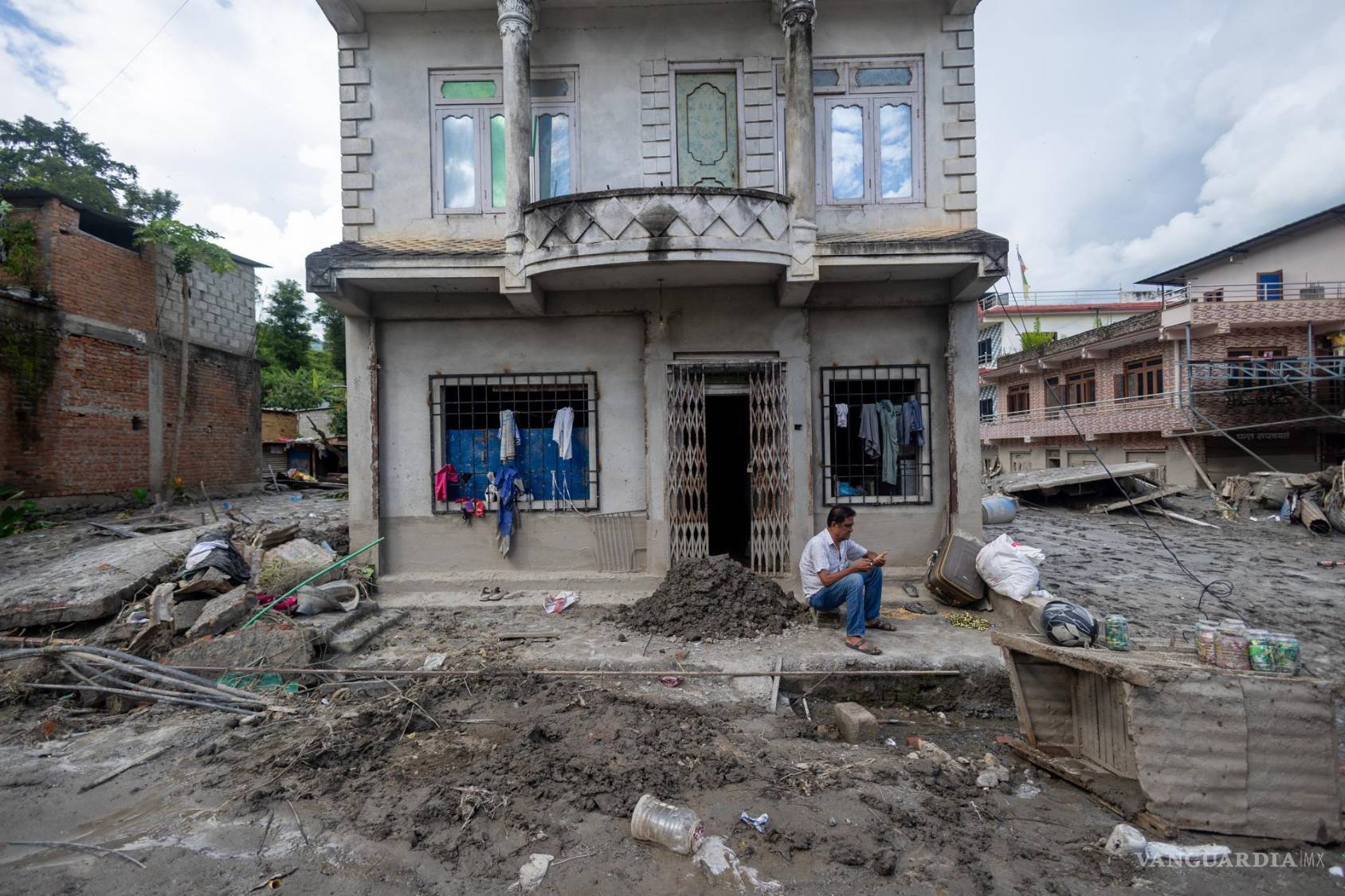 $!Un hombre está sentado frente a un edificio afectado por una inundación de origen glaciar cerca de la frontera entre Nepal y China, en Trishuli Bazar, Nuwakot, Nepal.