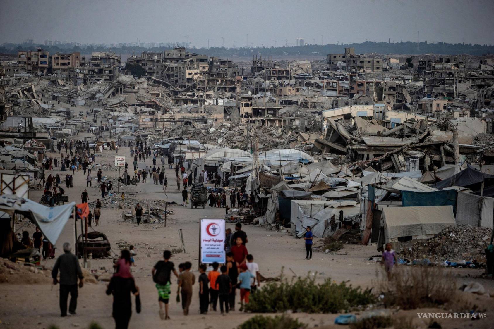 $!Palestinos caminan entre casas destruidas en Jabaliya, ciudad de Gaza. Cerca de 1.9 millones de personas en Gaza, casi el 90% de la población, han sido desplazadas.
