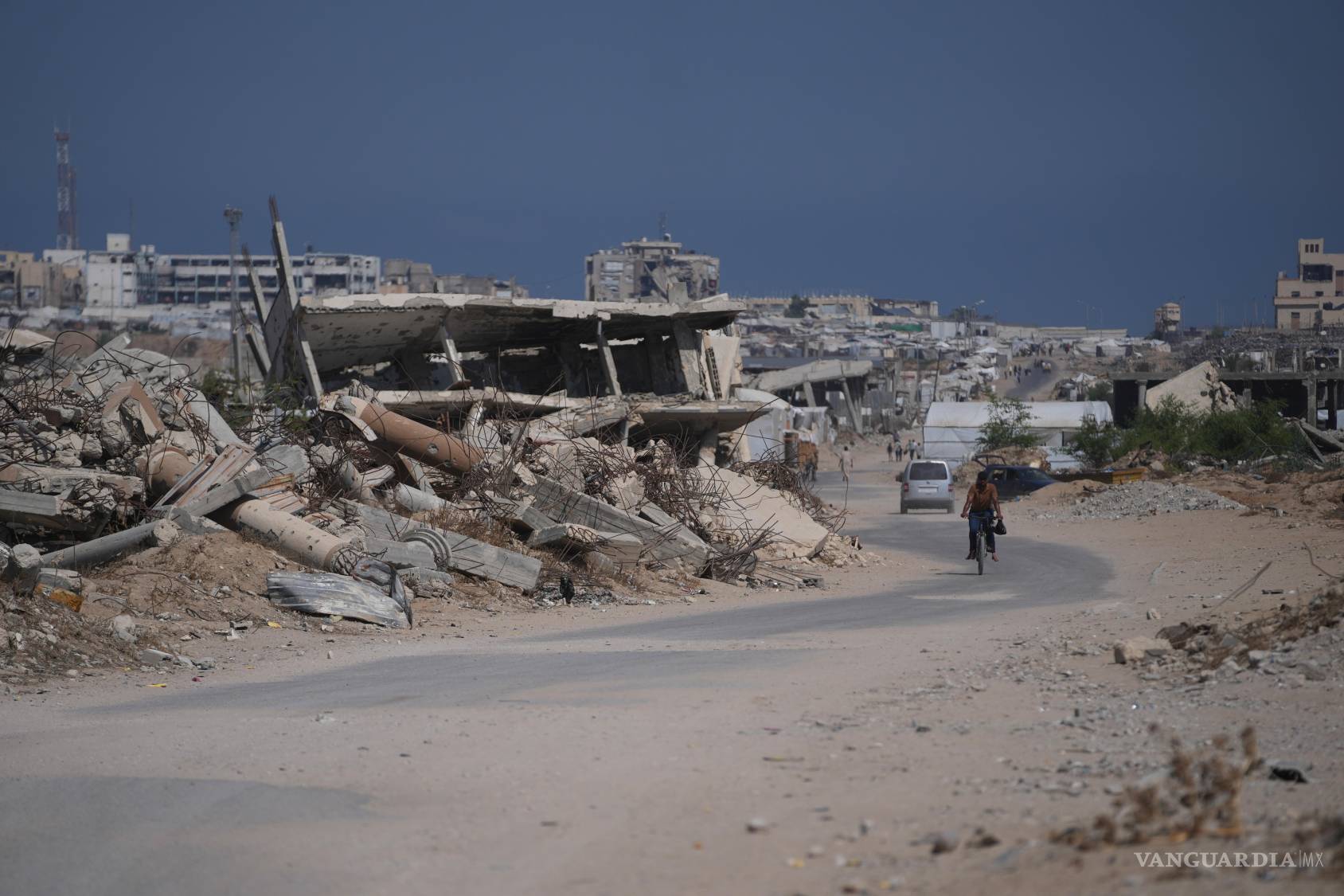 $!Un palestino pasa en bicicleta junto a escombros de edificios destruidos durante la guerra entre Israel y Hamás, en Jan Yunis, en el sur de Gaza, el 31 de julio de 2026.
