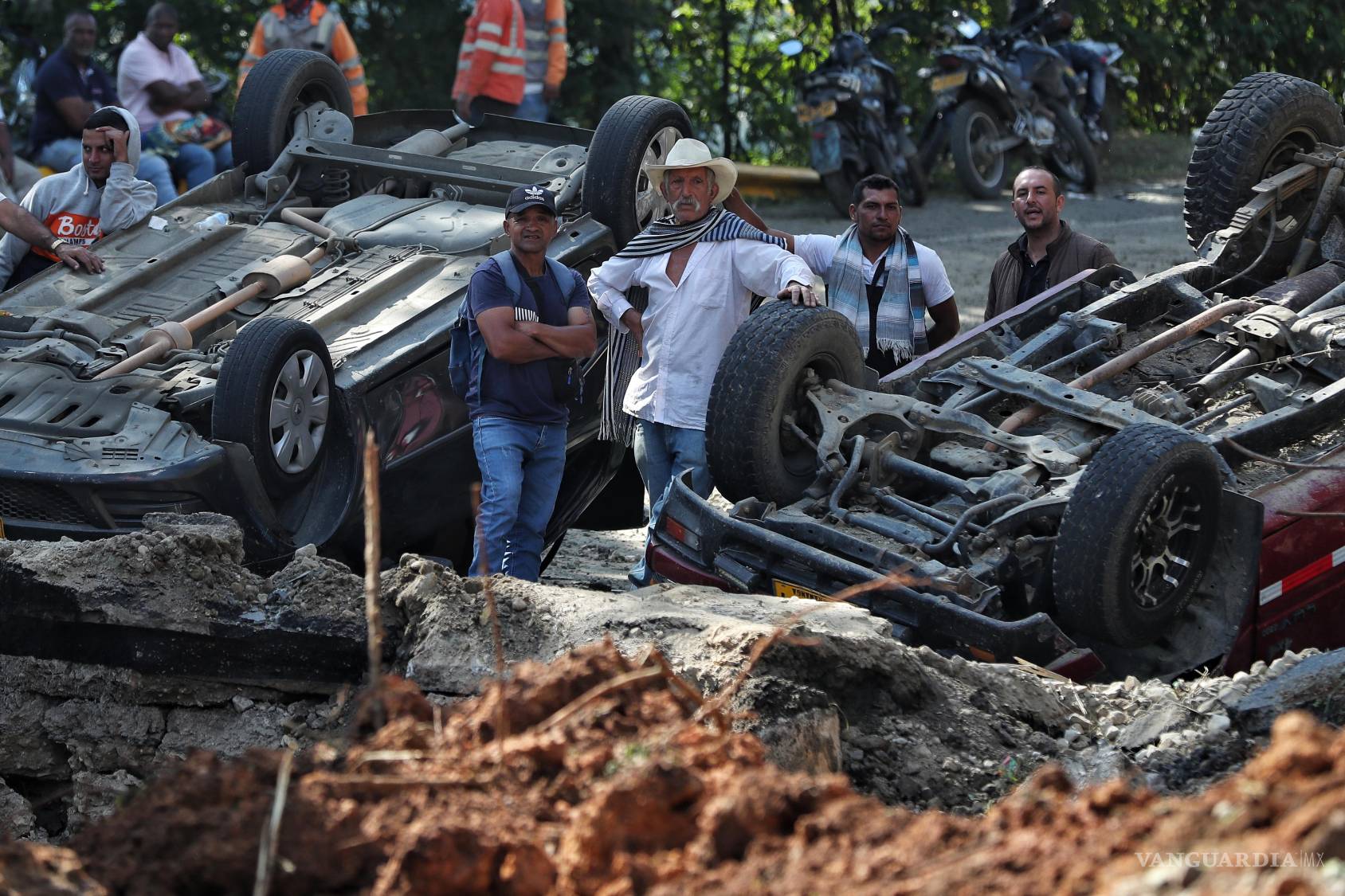 $!Gente de pie en el lugar de un ataque en la autopista Panamericana en Cajibio, Colombia donde al menos una docena de personas murieron.