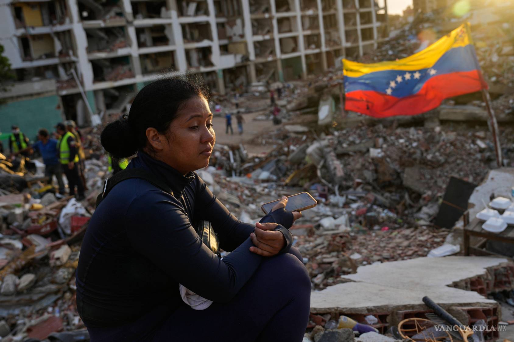 $!Estefany Landaez permanece sentada entre los escombros de un edificio esperando encontrar a sus dos hijos tras los terremotos en La Guaira, Venezuela.