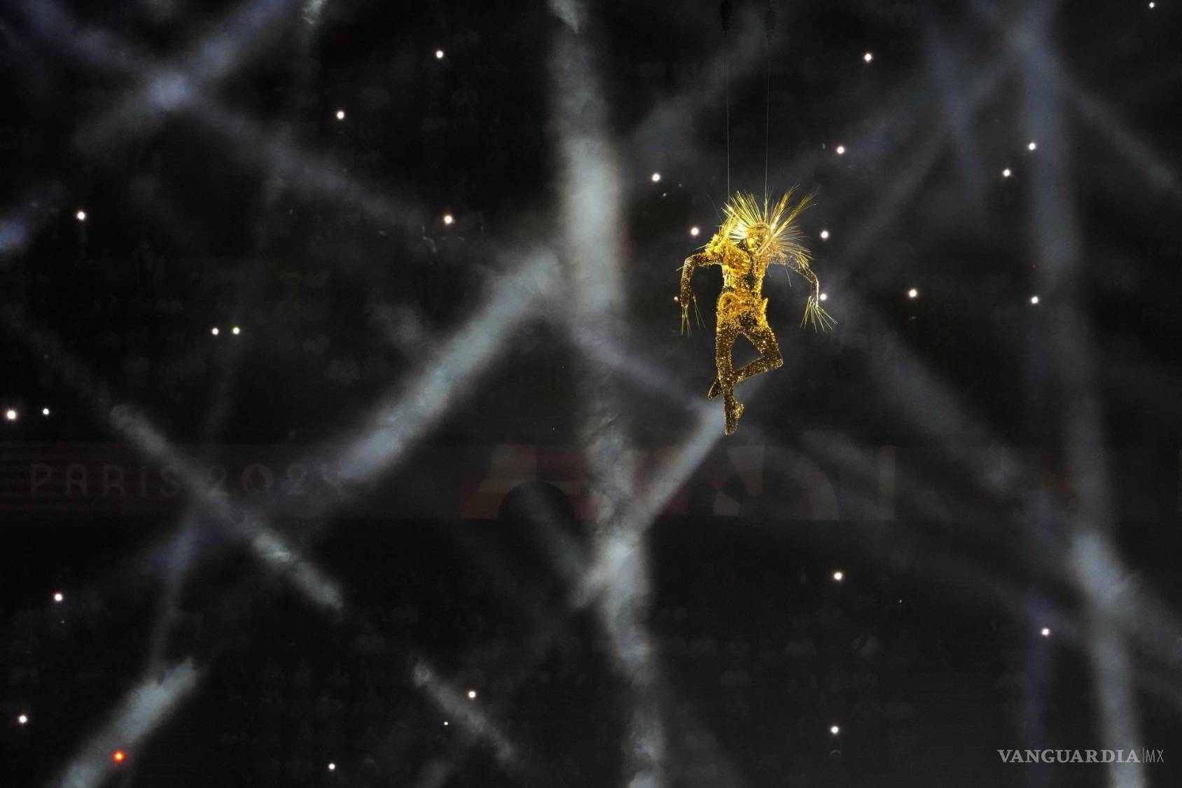 $!Figuras enmascaradas descienden del techo del estadio en una impresionante danza contemporánea, descubriendo los anillos olímpicos suspendidos sobre el centro.