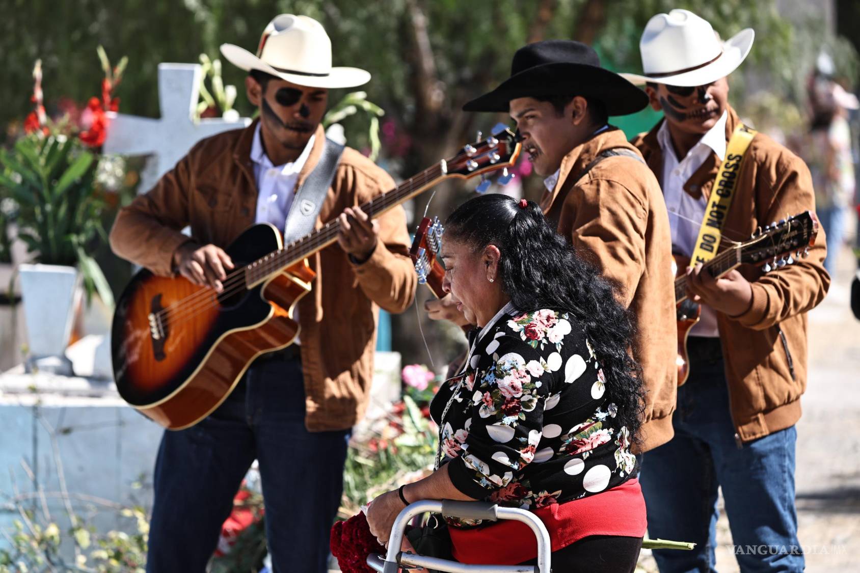 $!Grupos musicales recorren los pasillos de los panteones tocando melodías que animan la jornada.