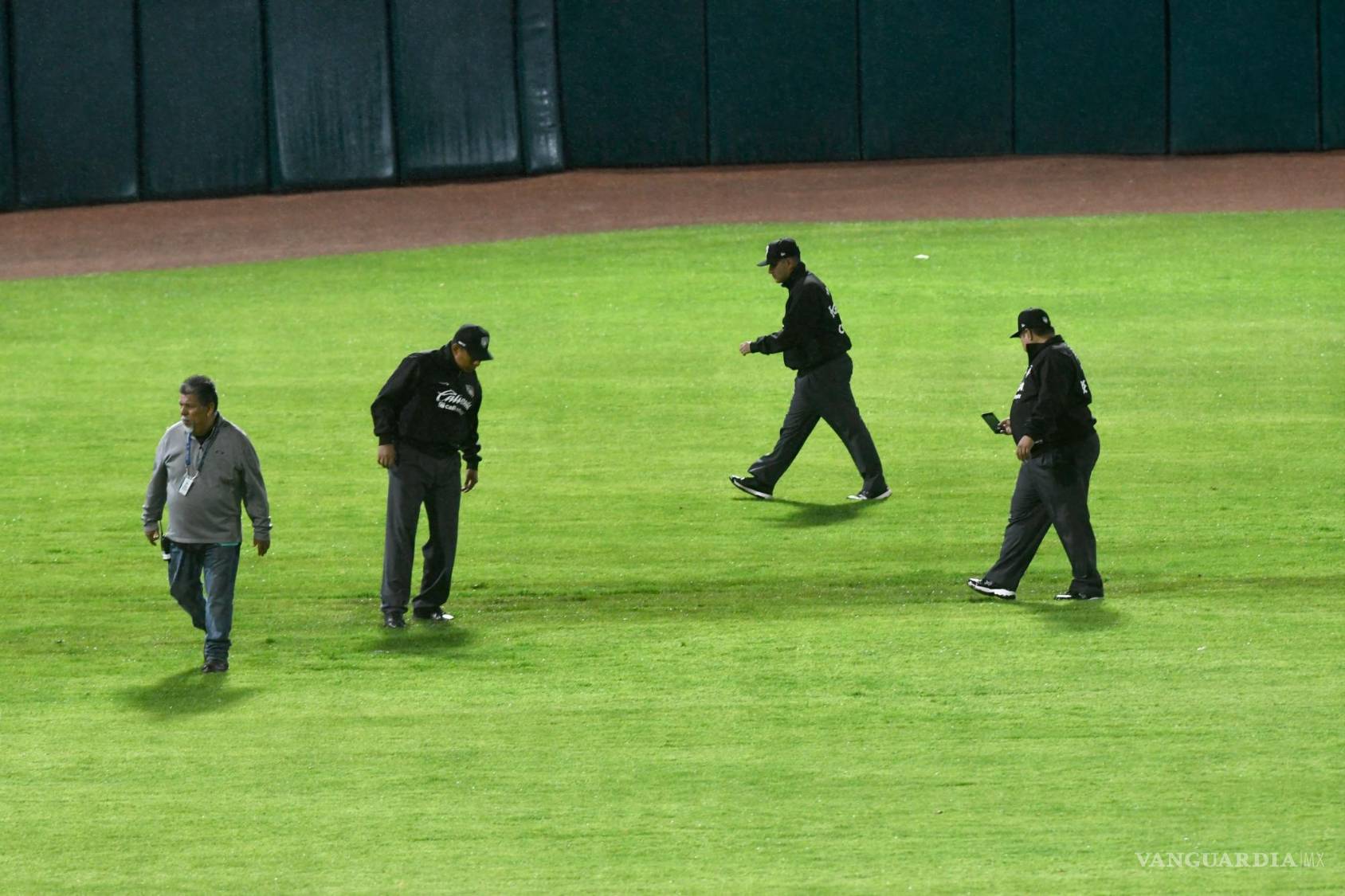 $!Los ampayers revisaron el campo para determinar la situación.