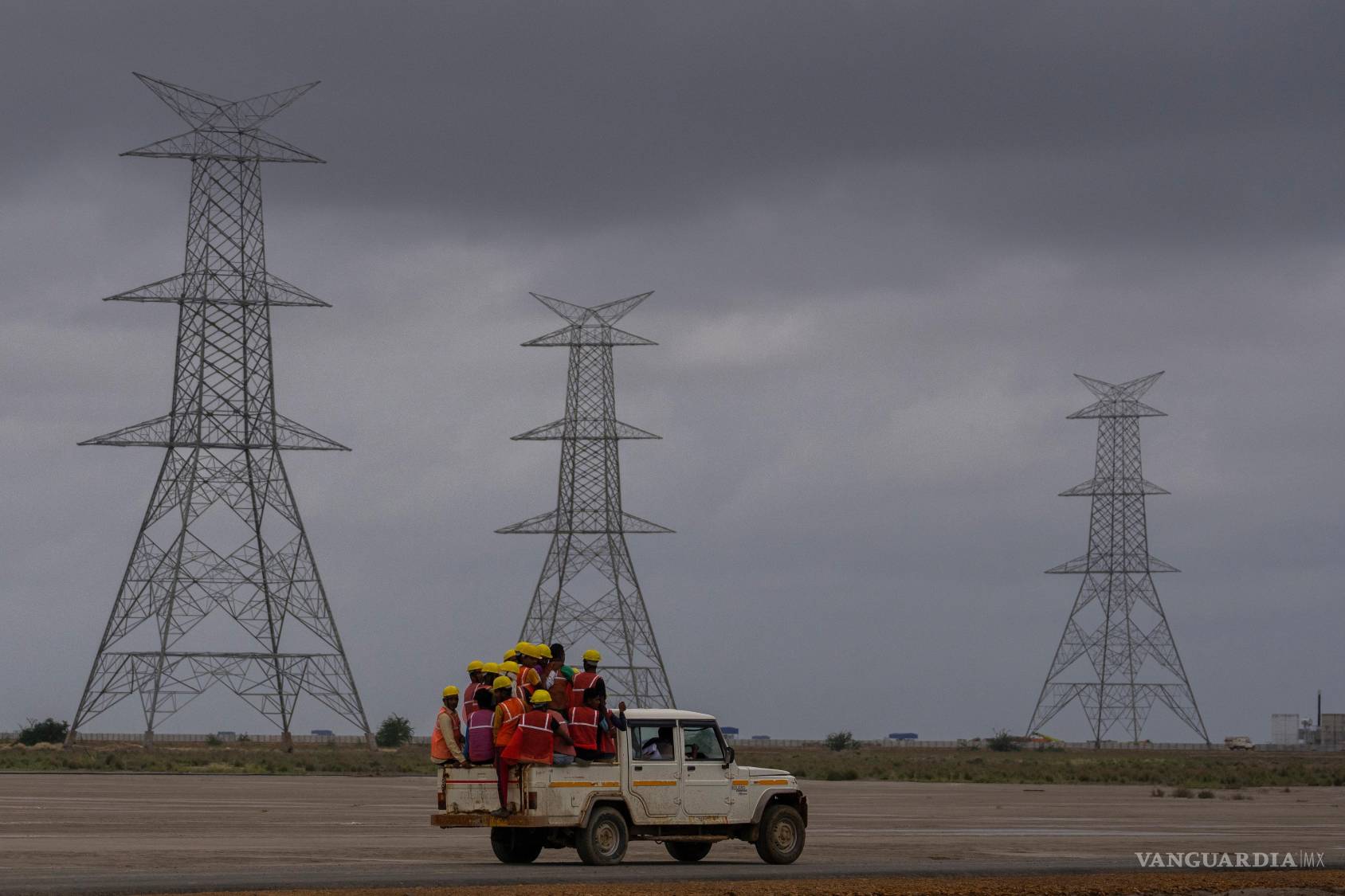 $!Trabajadores viajan hacia el sitio de construcción del Parque de Energía Renovable de Adani Green Energy Limited, en el desierto salino de la aldea de Karim Shahi.