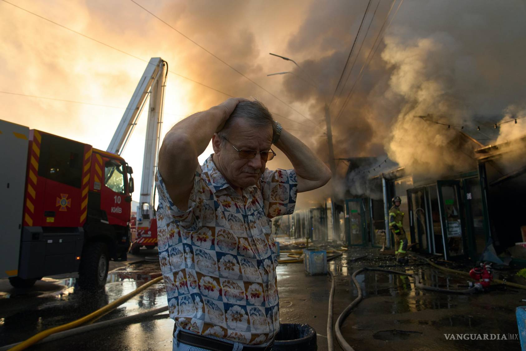 $!El librero Alexander Bahlai se lamenta mientras los bomberos intentan sofocar un incendio en un mercado de libros en Kiev, tras un ataque con misiles rusos.