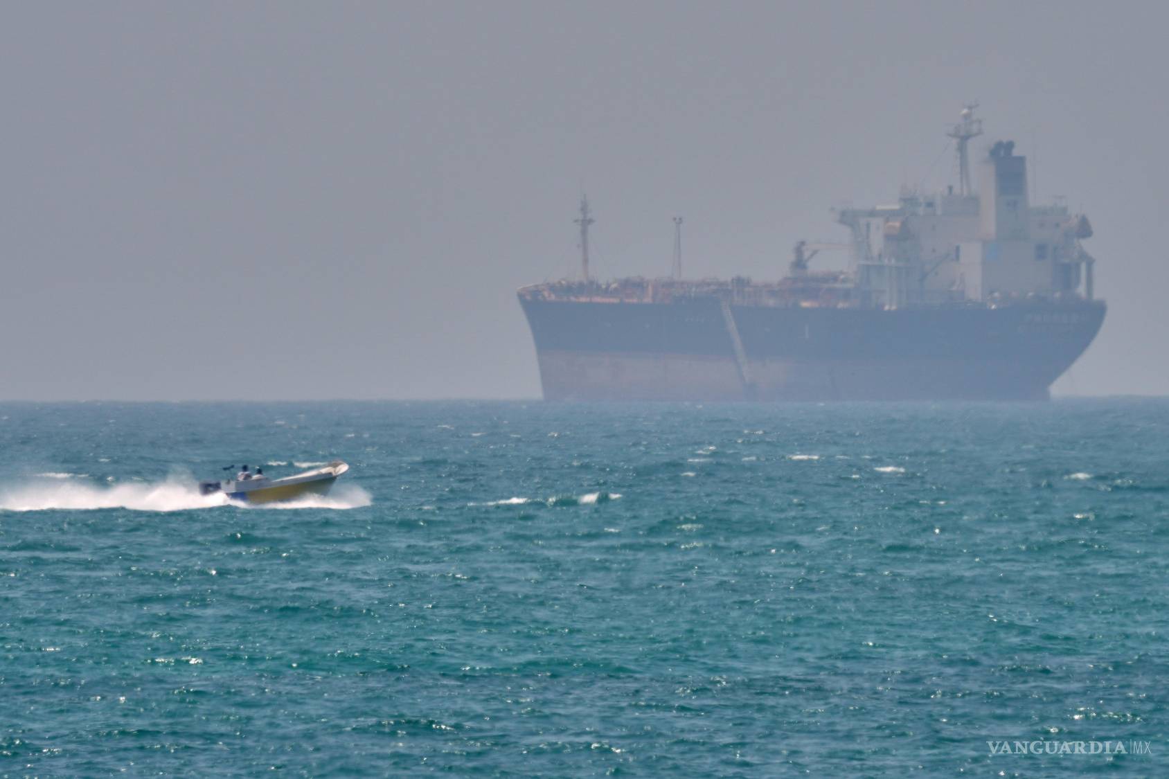 $!Un barco navega junto a un petrolero anclado en el estrecho de Ormuz, frente a la costa de la isla de Qeshm, Irán.